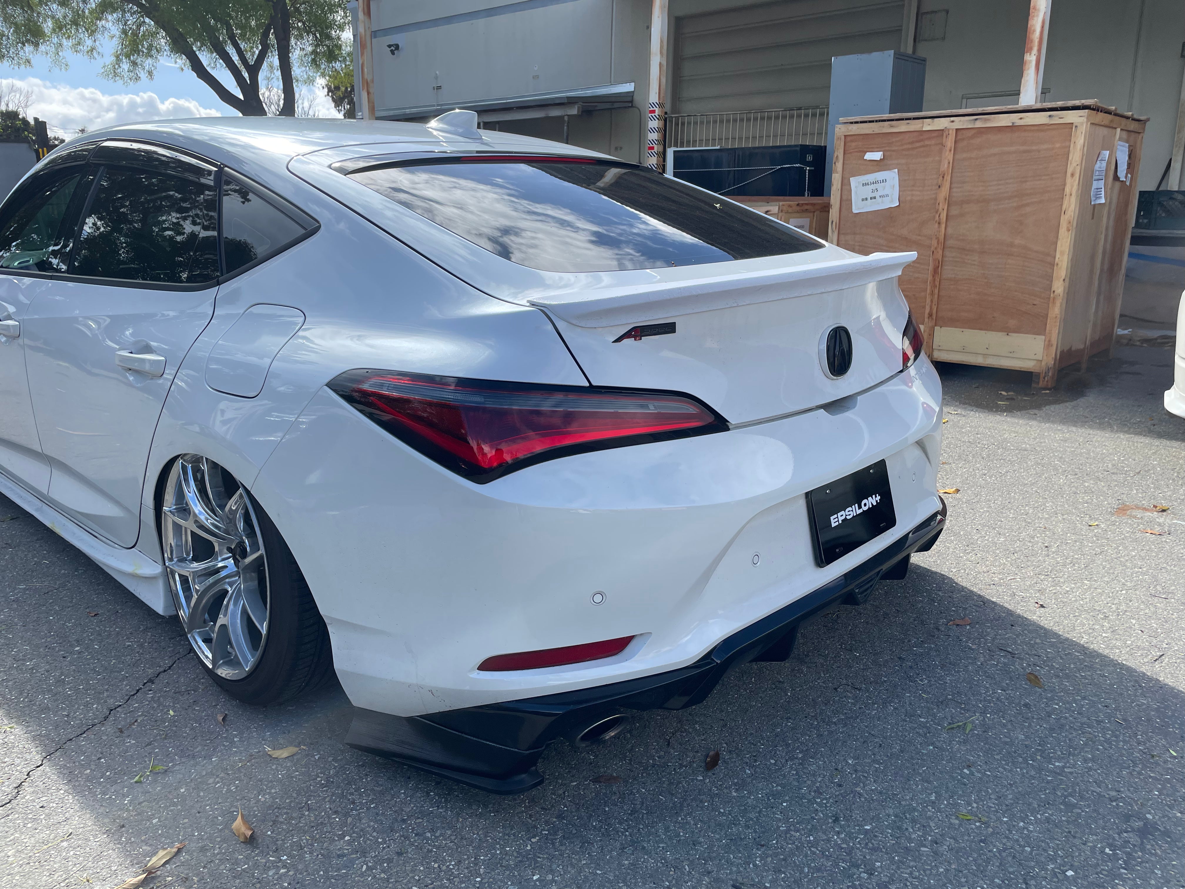 White Acura Integra with the Epsilon+ rear trunk lip outside the workshop