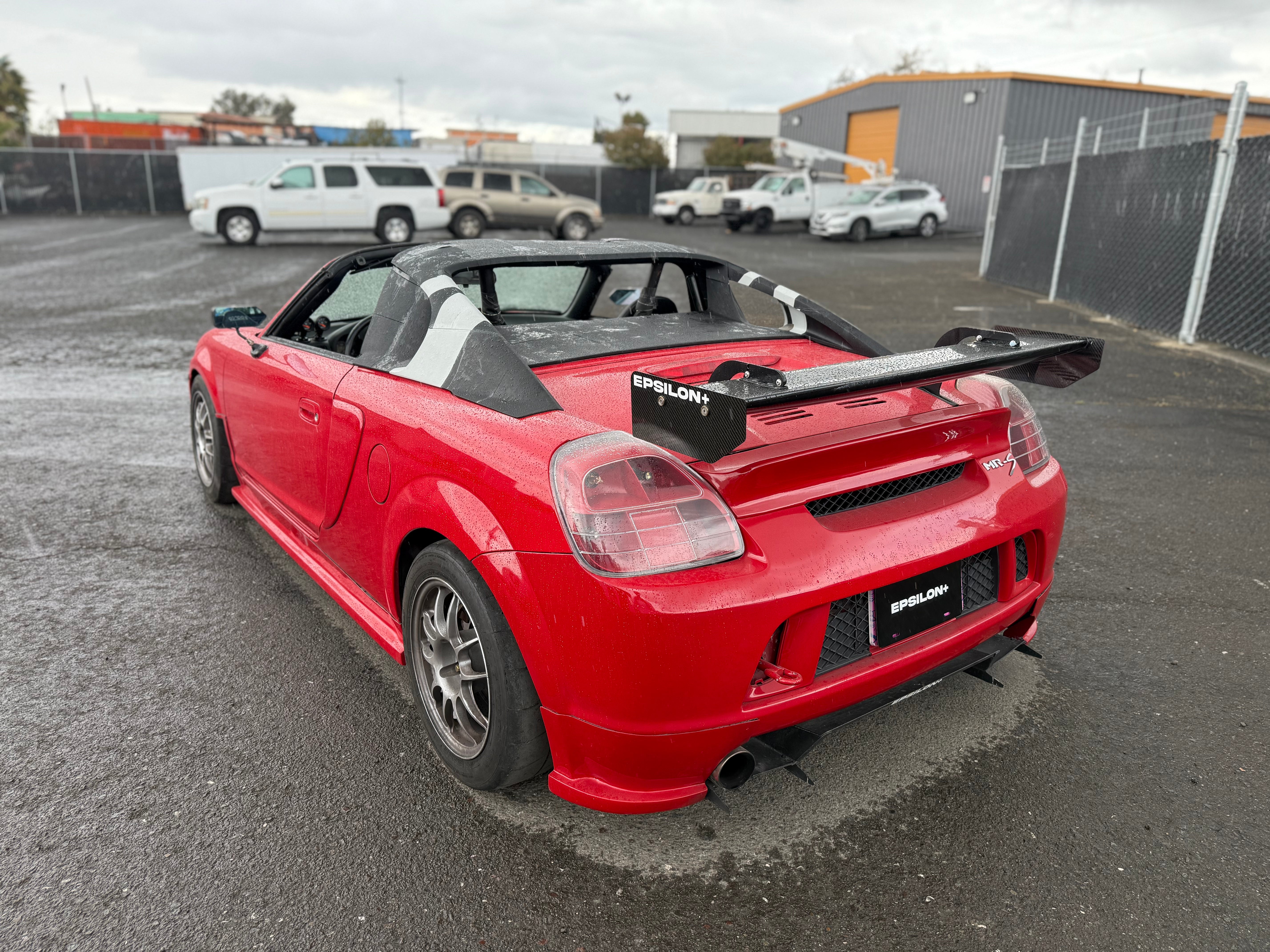 Rear three-quarter view of a red Toyota MR2 Spyder with rear wing fitted