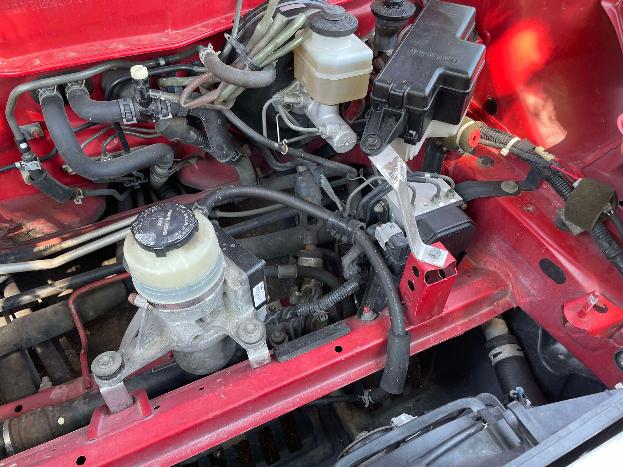 View into the MR2 Spyder front compartment showing the hood vent opening above the master cylinder