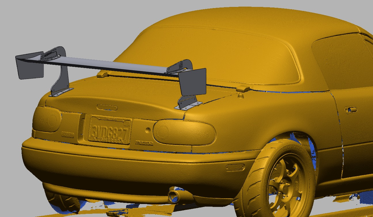NA Miata rear quarter close-up showing the 47.5" swan-mount TC Wing endplates and deck lid mounting