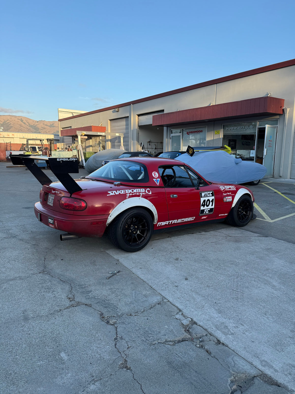66.5" TC Wing on NA Miata, rear quarter view from the driver side showing full wing span