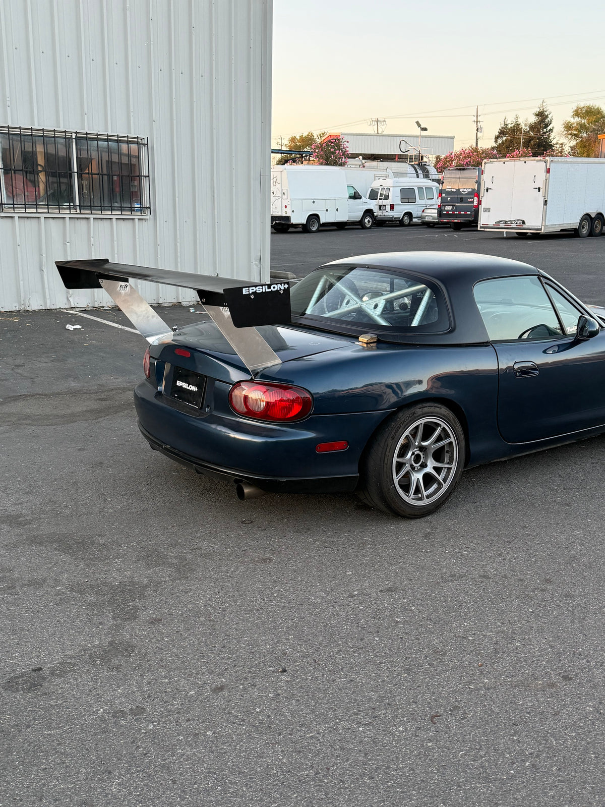 Dark blue Mazda Miata NB with the Epsilon+ TC wing, passenger-side rear three-quarter view