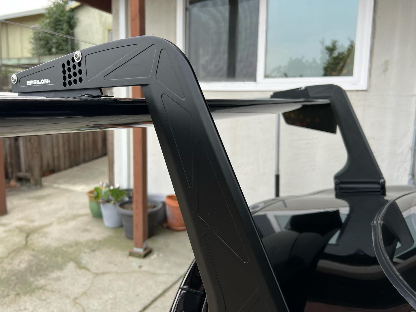 Close-up of the swan mount and endplate on a black RX-7 GT wing