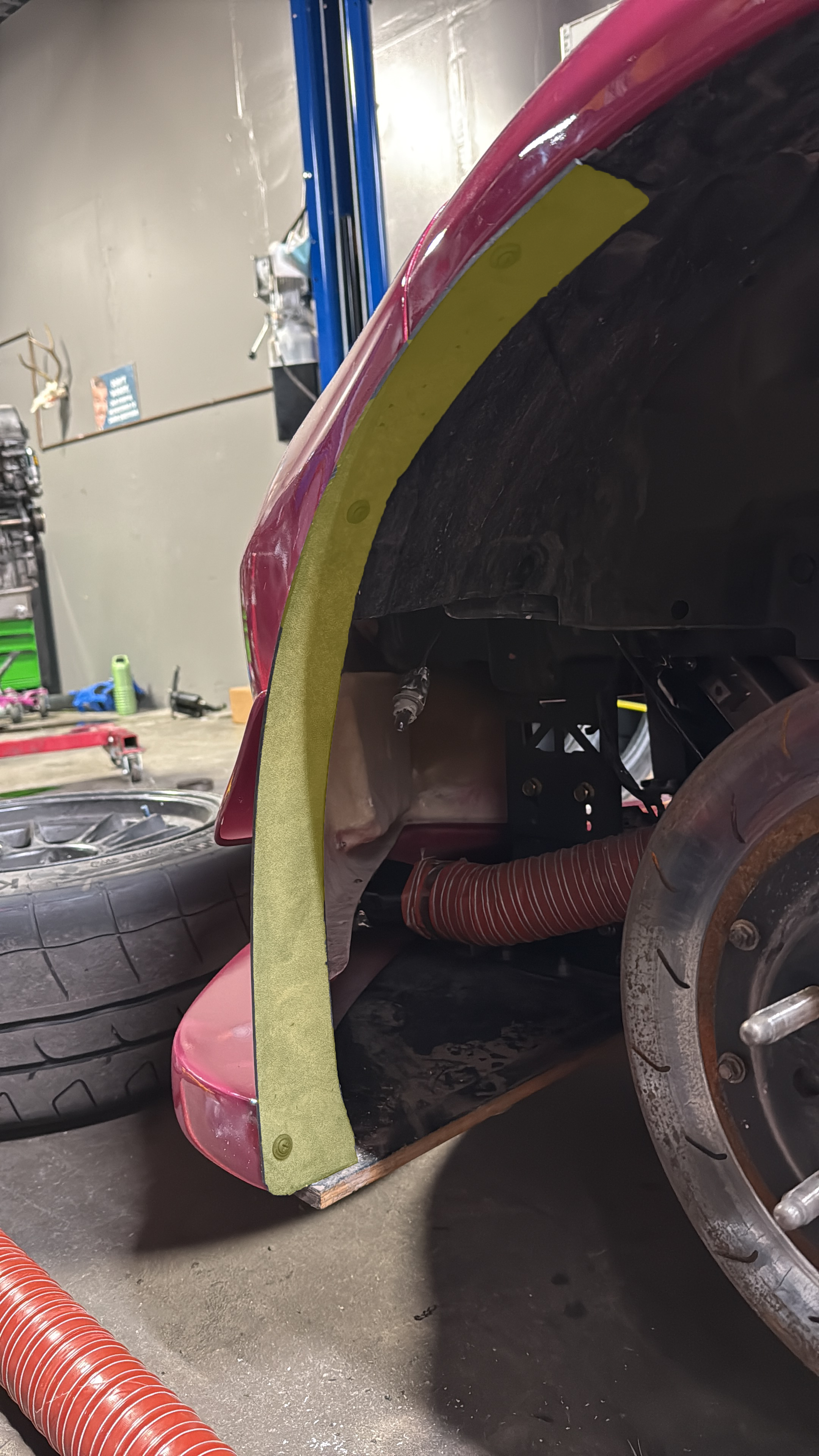 Close-up of the tire spat mounted in front of the wheel on a pink Miata NC