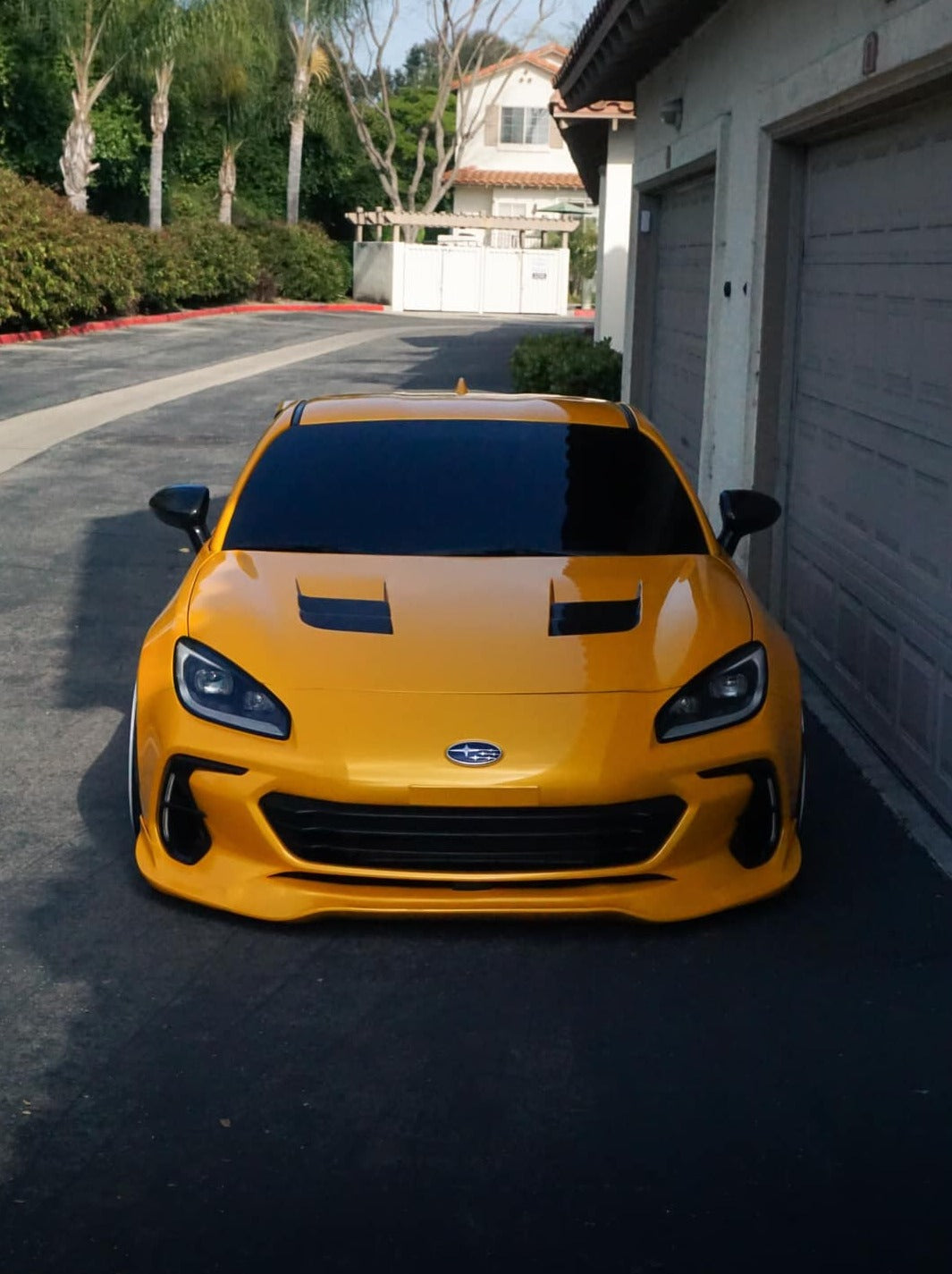 Yellow Subaru BRZ ZN8 with front lip parked in a residential driveway