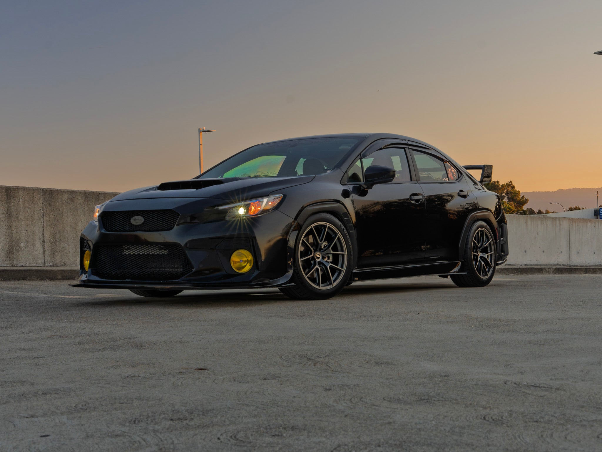 Front-on view of a black Subaru WRX VB with prototype front bumper at sunset