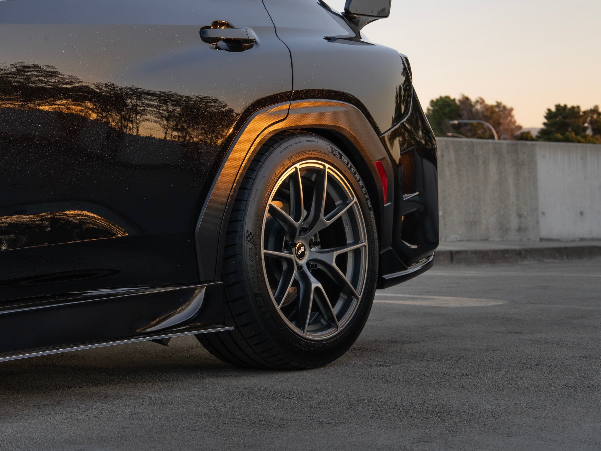 Close-up of the side skirt intake and front wheel on a black Subaru WRX VB
