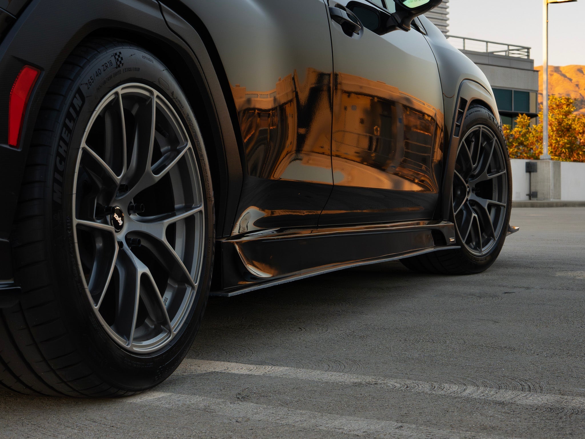 Close-up of the side skirt and wheel well on a black Subaru WRX VB