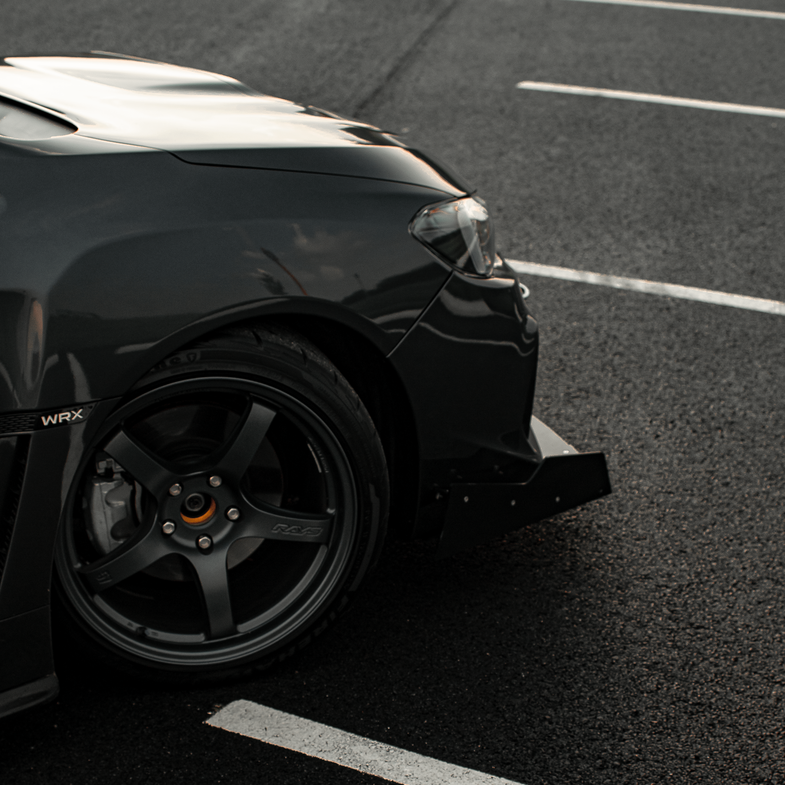 Close-up of the front splitter on a gray WRX VA fender and wheel