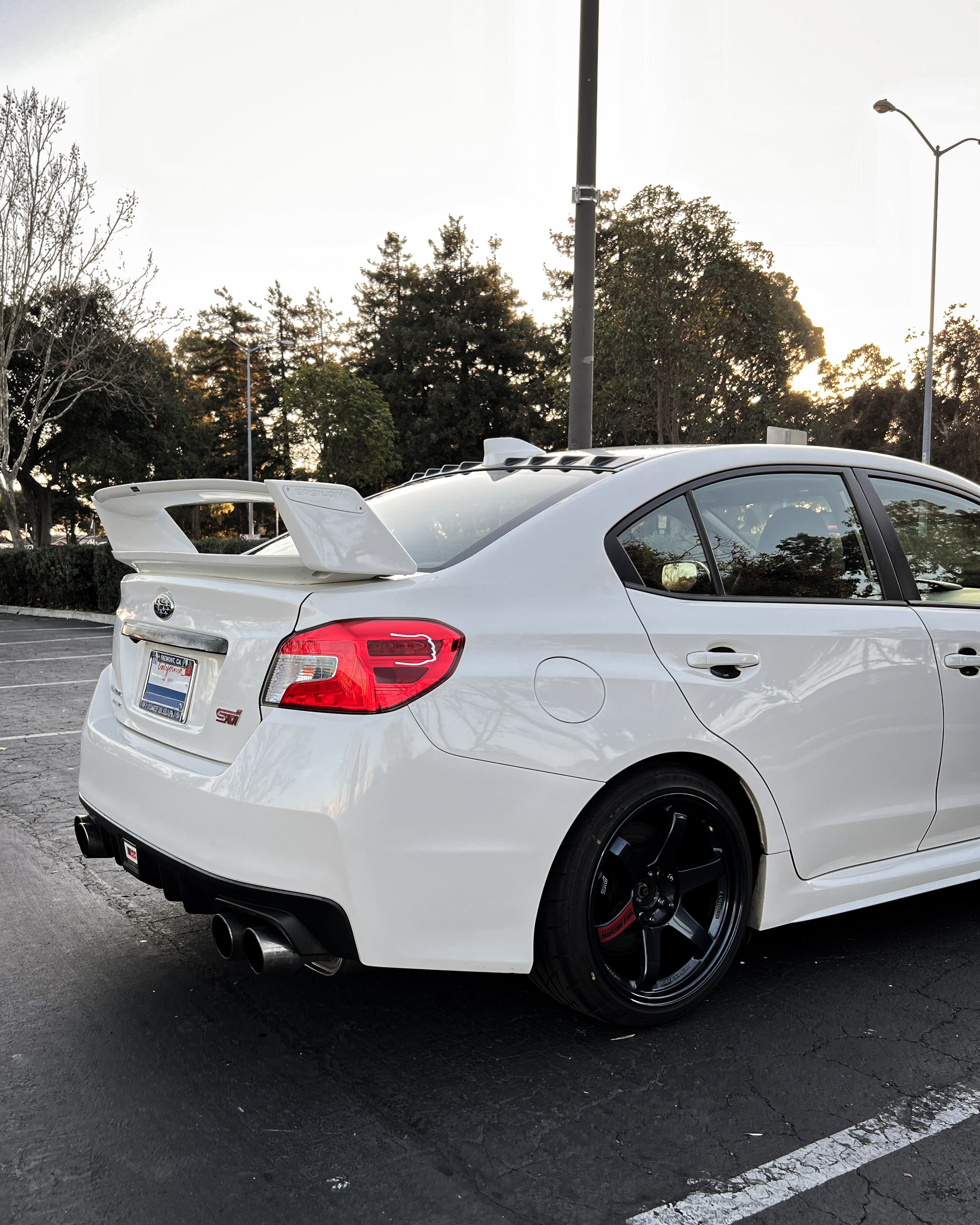 White Subaru WRX VA with the Epsilon+ WRC wing, rear three-quarter view