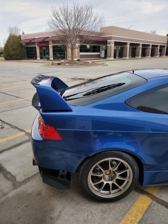 Rear view of a blue Acura RSX DC5 showing the lower spoiler extension on the wing