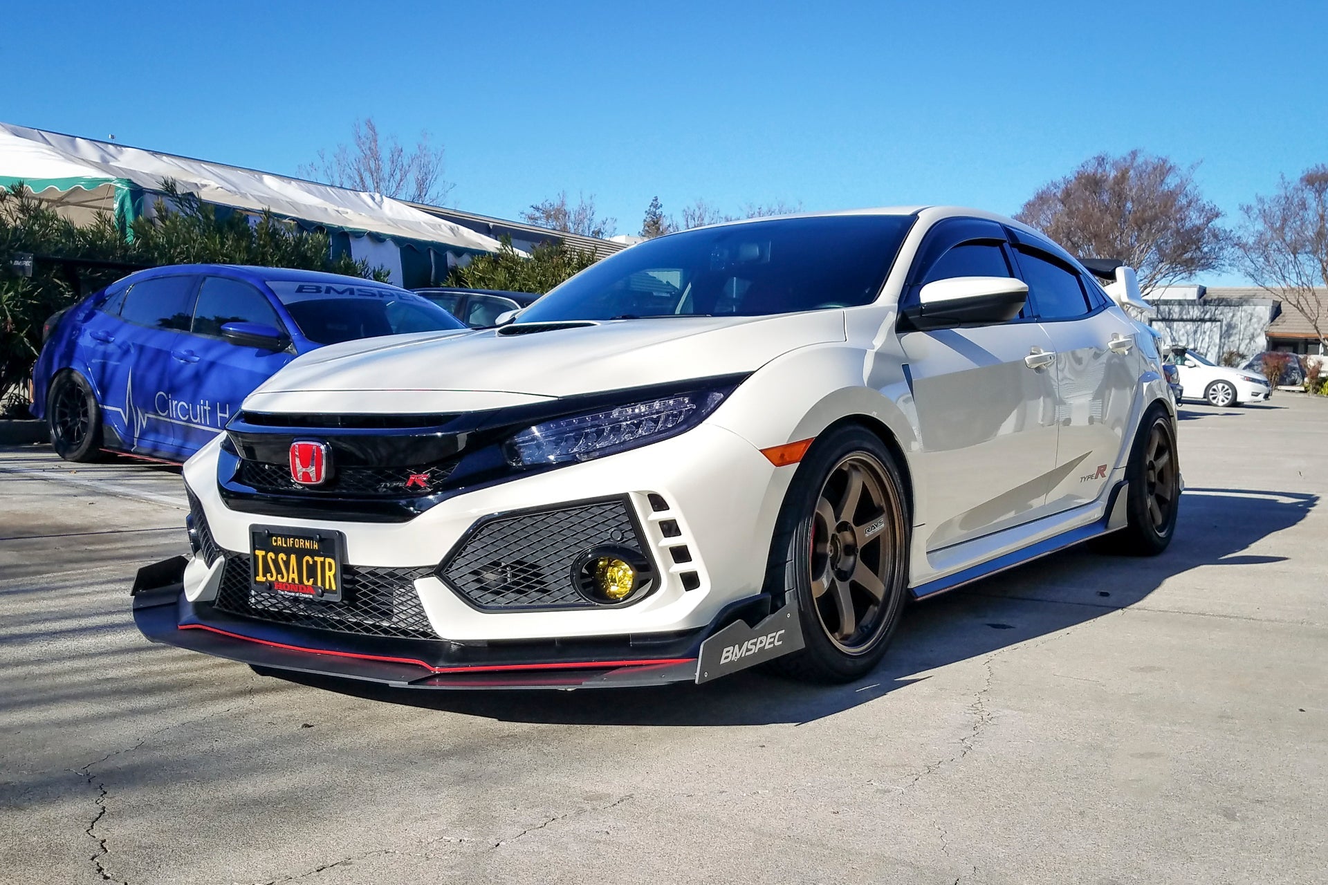 Front three-quarter view of a white Civic Type R FK8 with front splitter parked outdoors