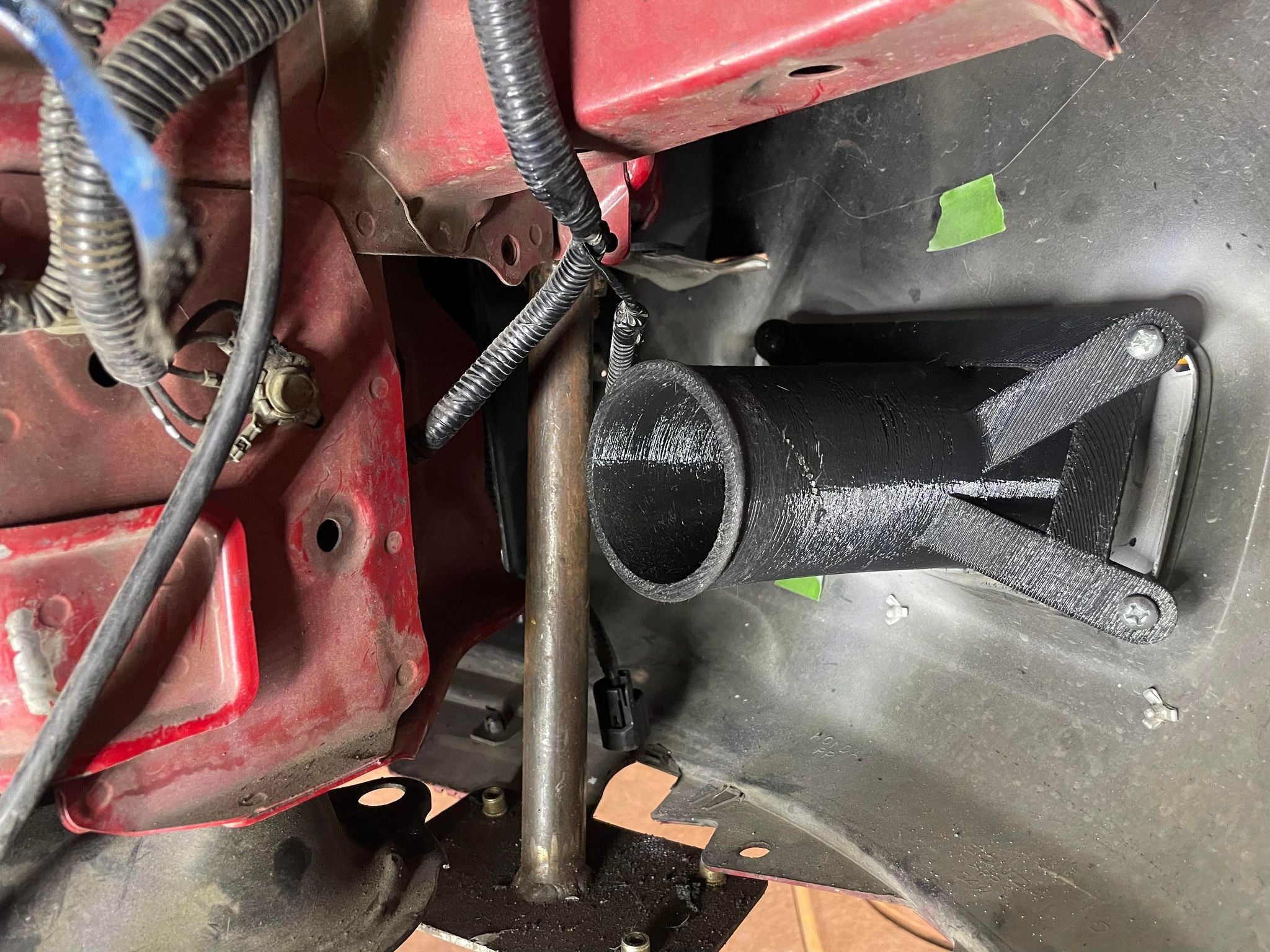 Close-up of the brake duct hose and mount installed behind the wheel
