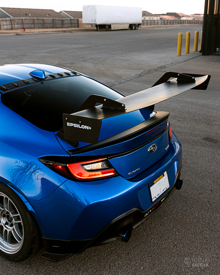 Rear three-quarter view of a blue Subaru BRZ ZN8 with GT wing in a parking lot
