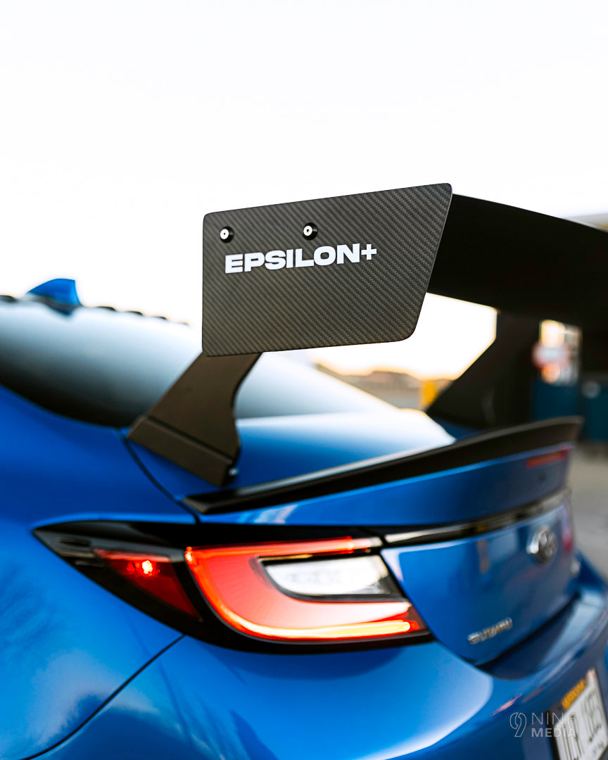 Close-up of the carbon fiber GT wing blade and endplate branding on a blue BRZ ZN8