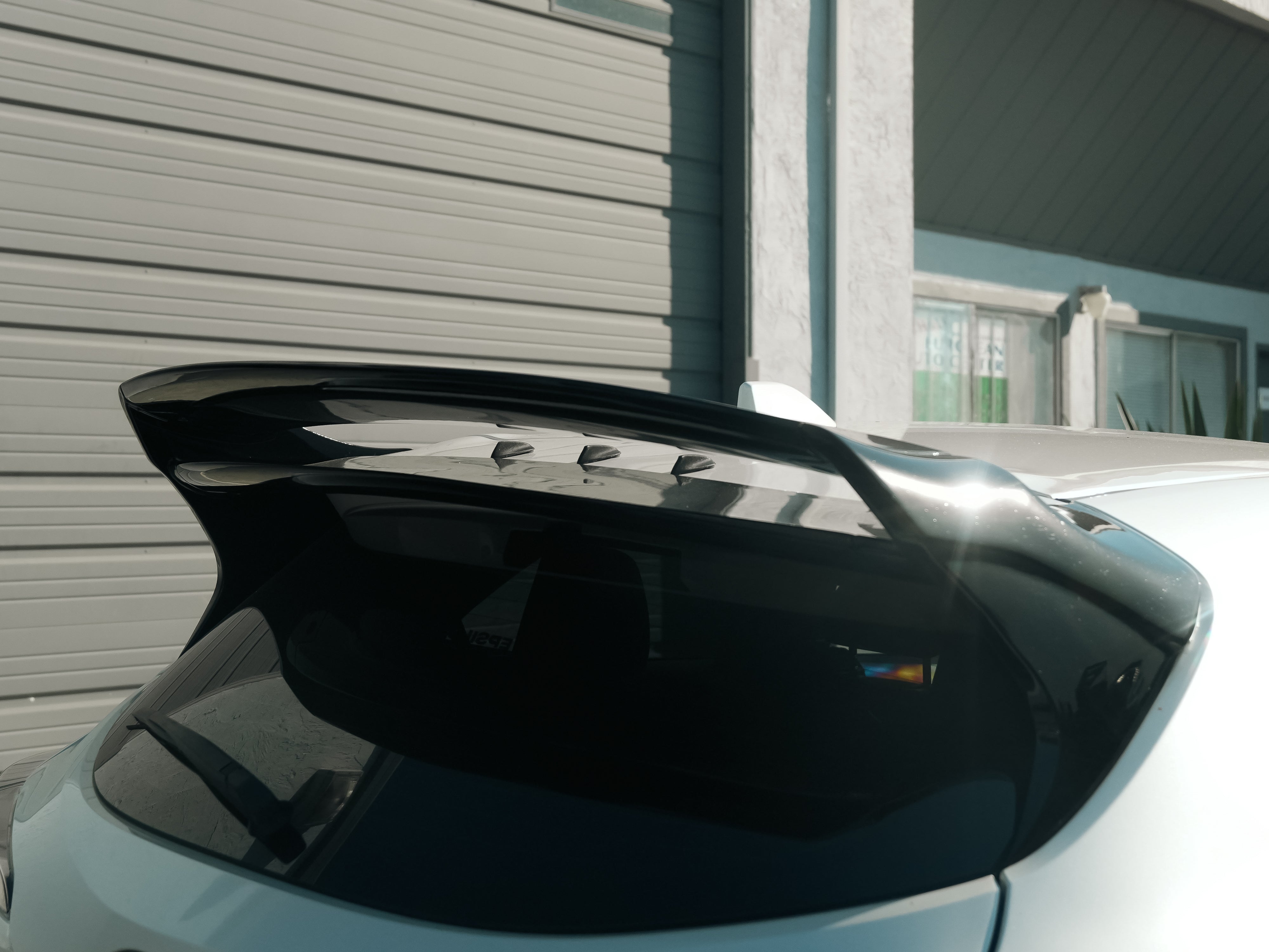Close-up of the GR Corolla rear wing with vortex generator plugs filling the mount holes