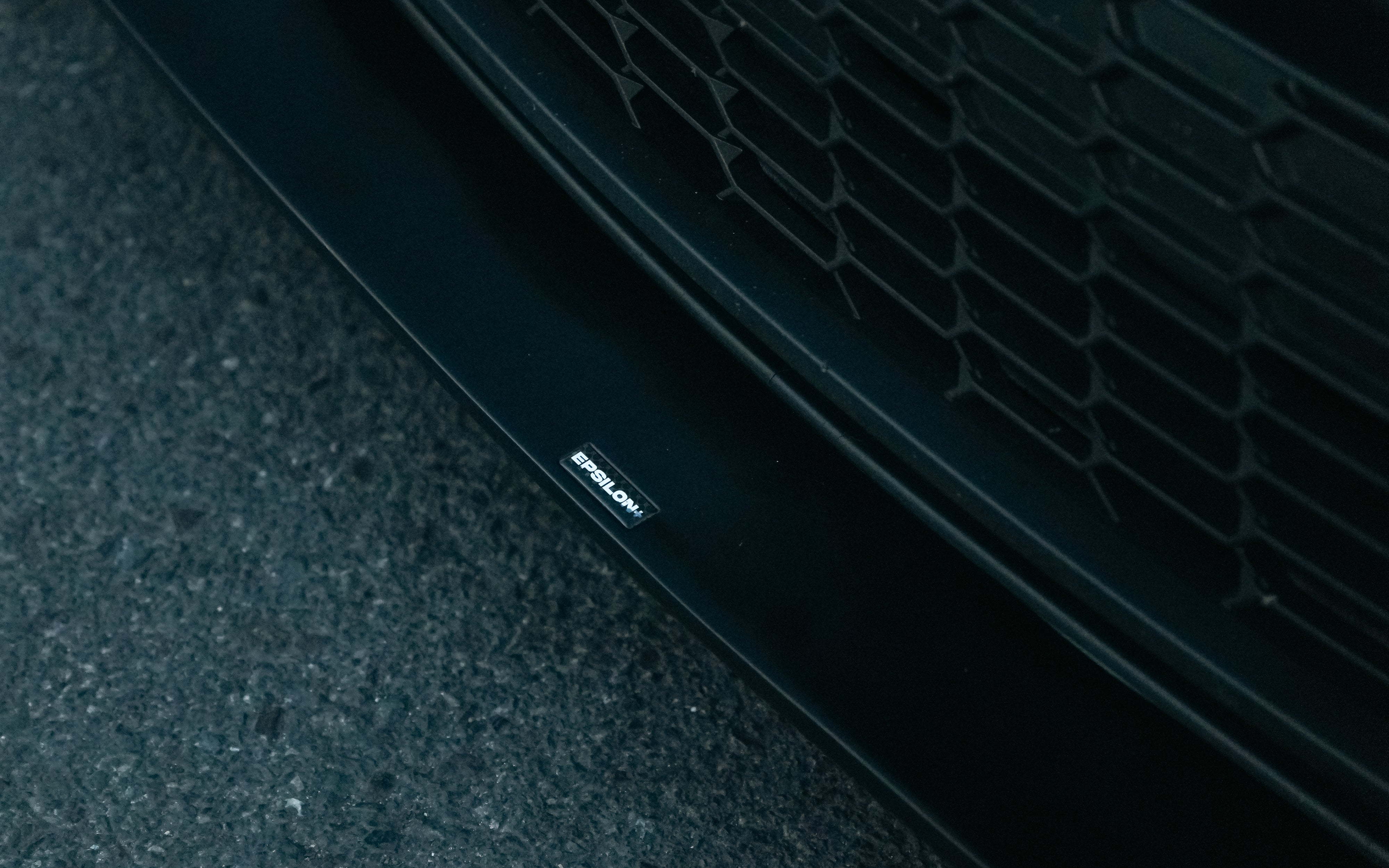 Close-up of the front lip V2 edge detail on a car in a parking garage at night
