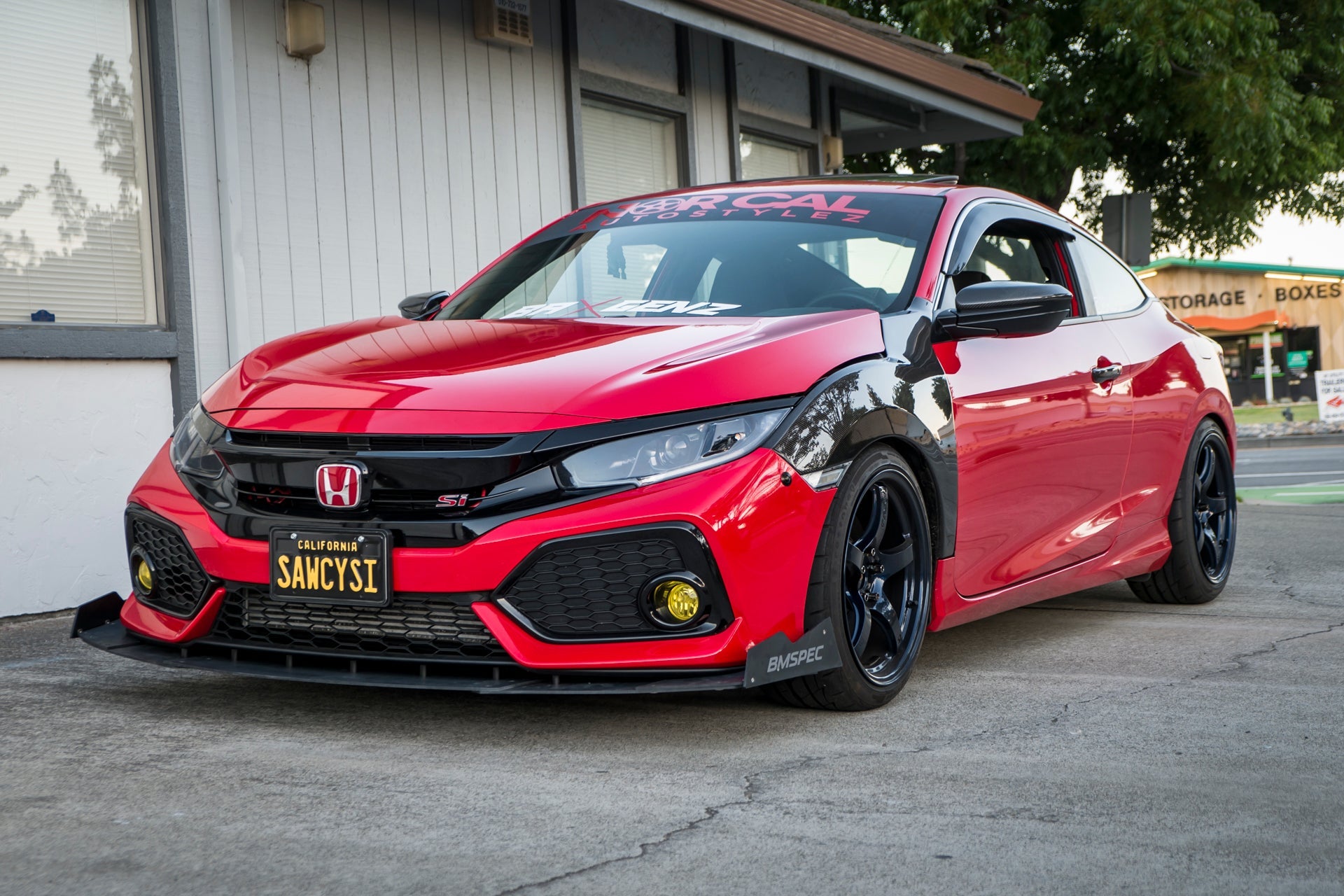 Front three-quarter view of a red and black Civic Si Coupe with front splitter