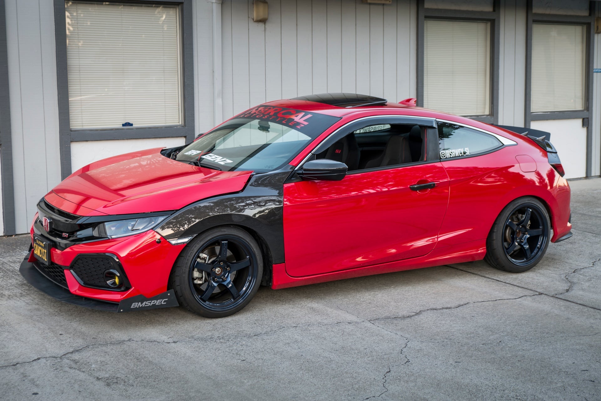 Side profile of a red and black Civic Si Coupe with front splitter