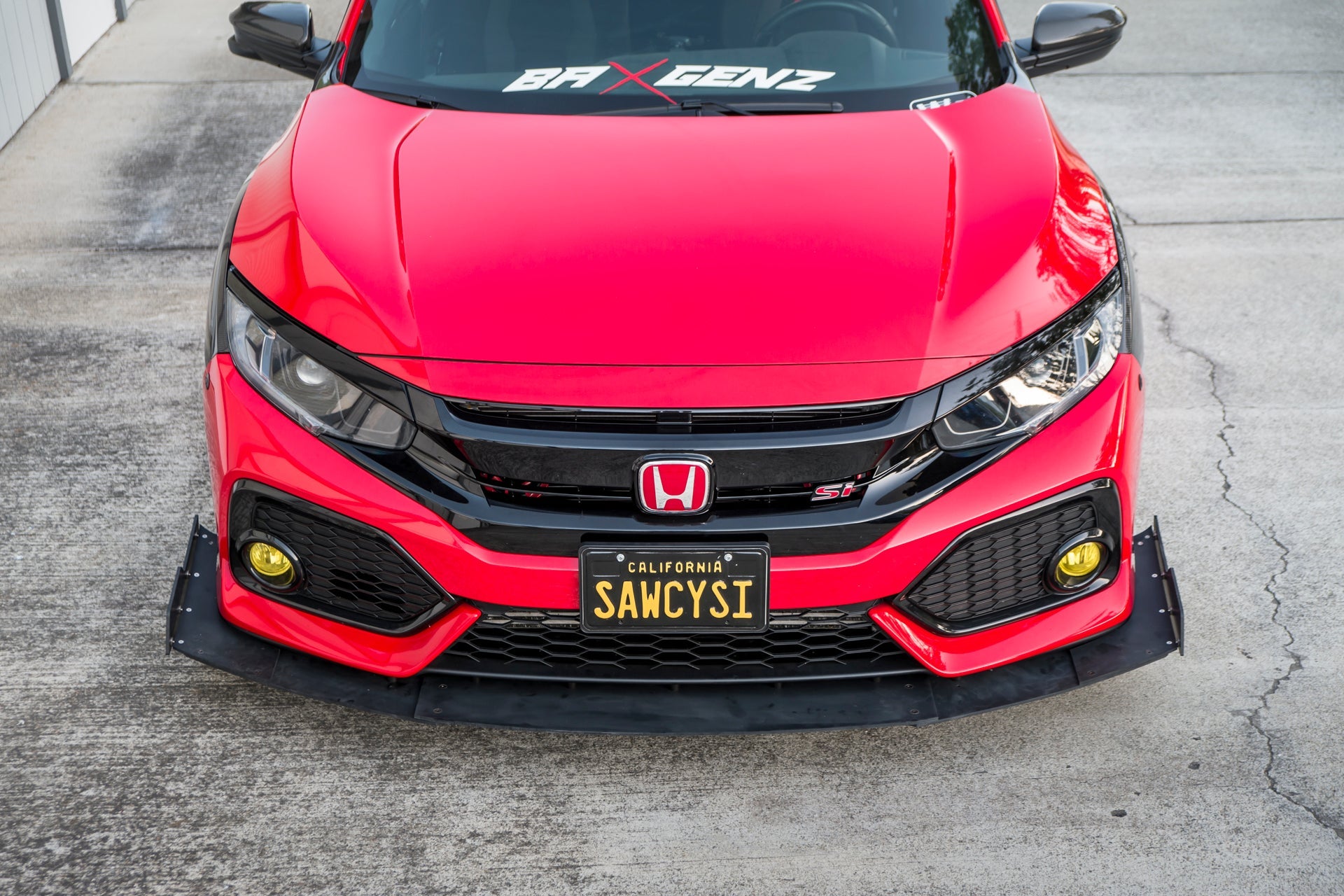 Front-on view of a red Civic Si Coupe with front splitter parked in a driveway