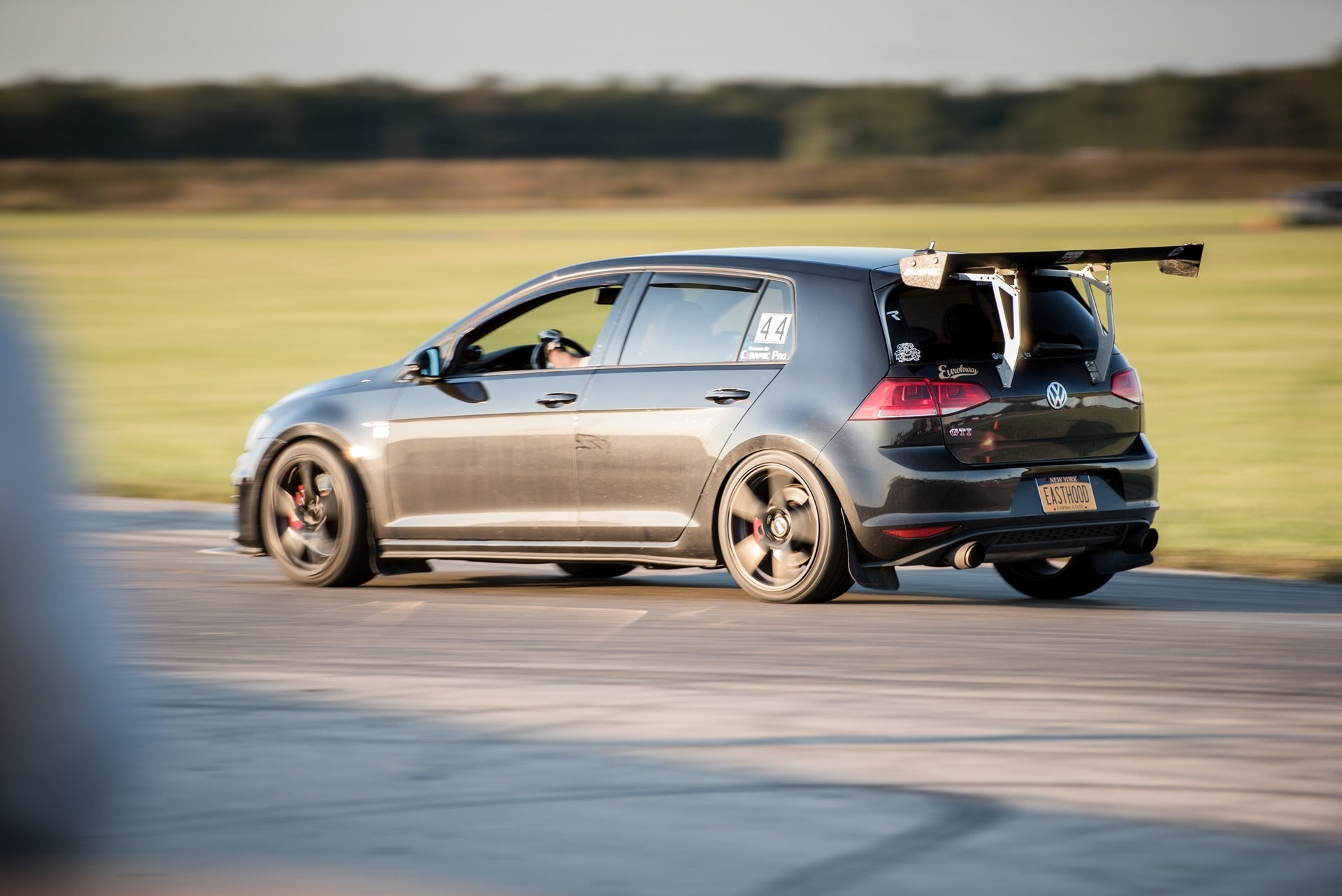 Rear three-quarter view of a gray Golf R with GT wing, low stance
