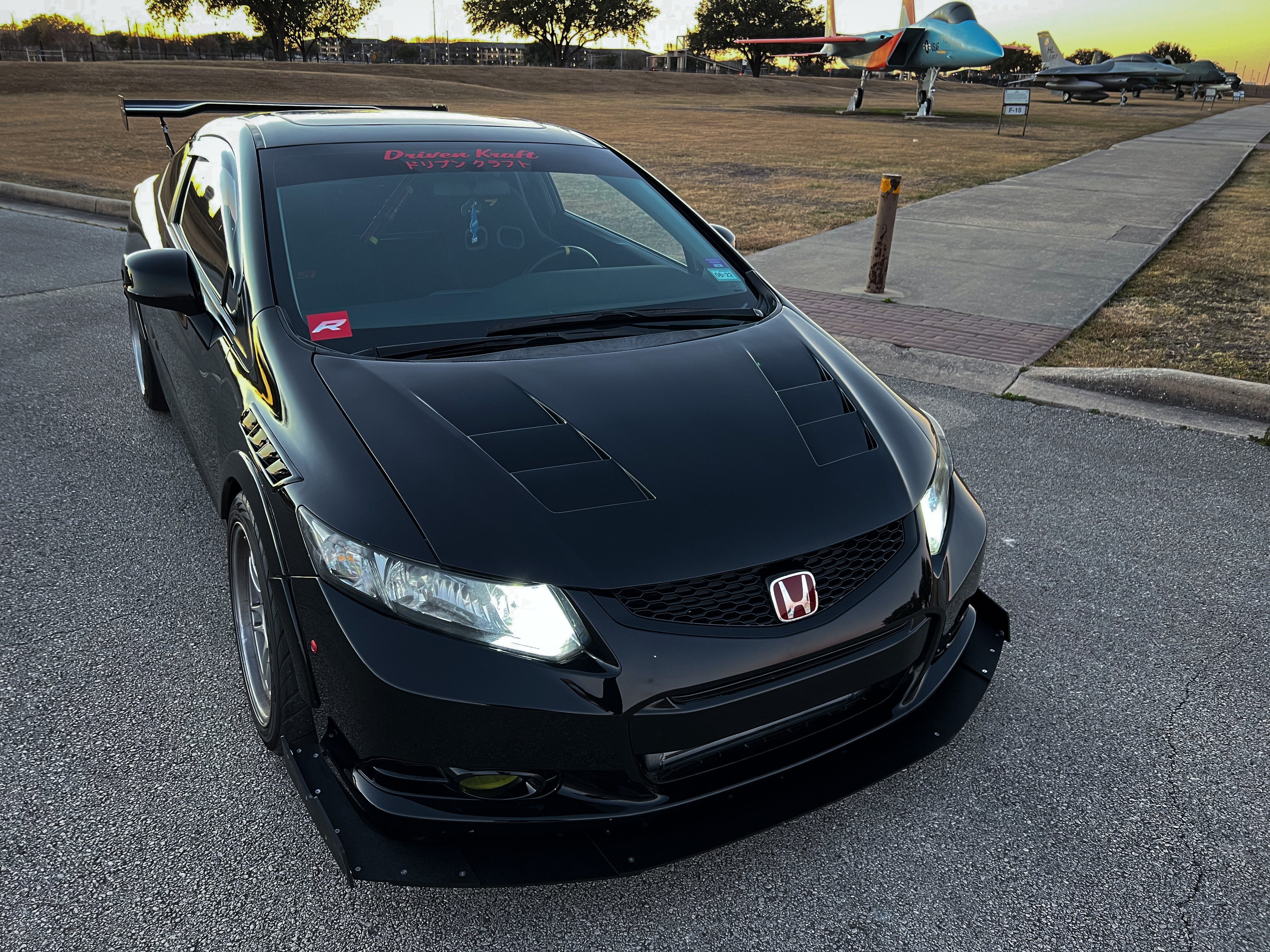 Front three-quarter view of a black Civic Si Coupe Zenki with front splitter at an airfield
