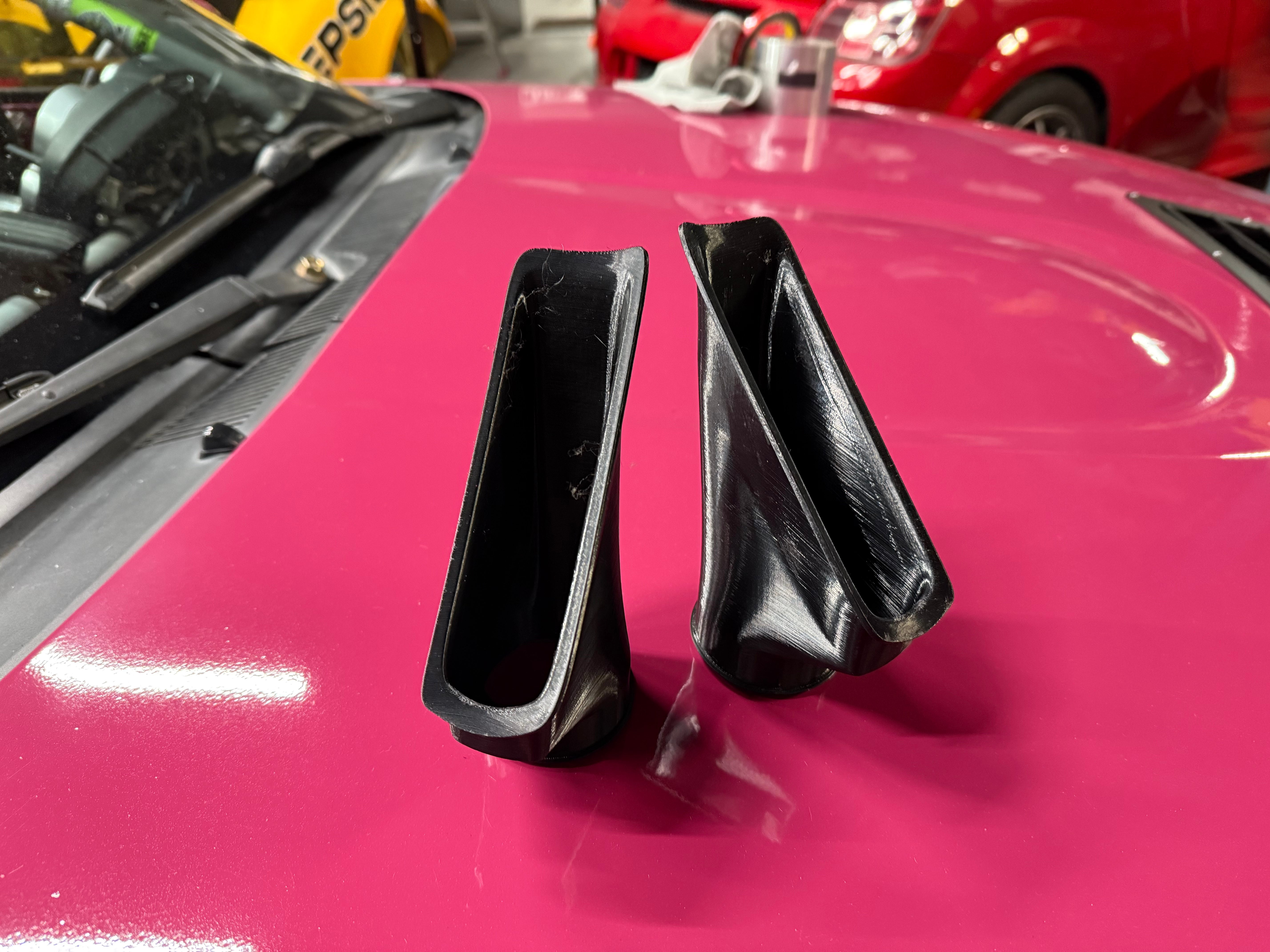Close-up of both brake duct inlets mounted side by side on a pink Miata NC bumper