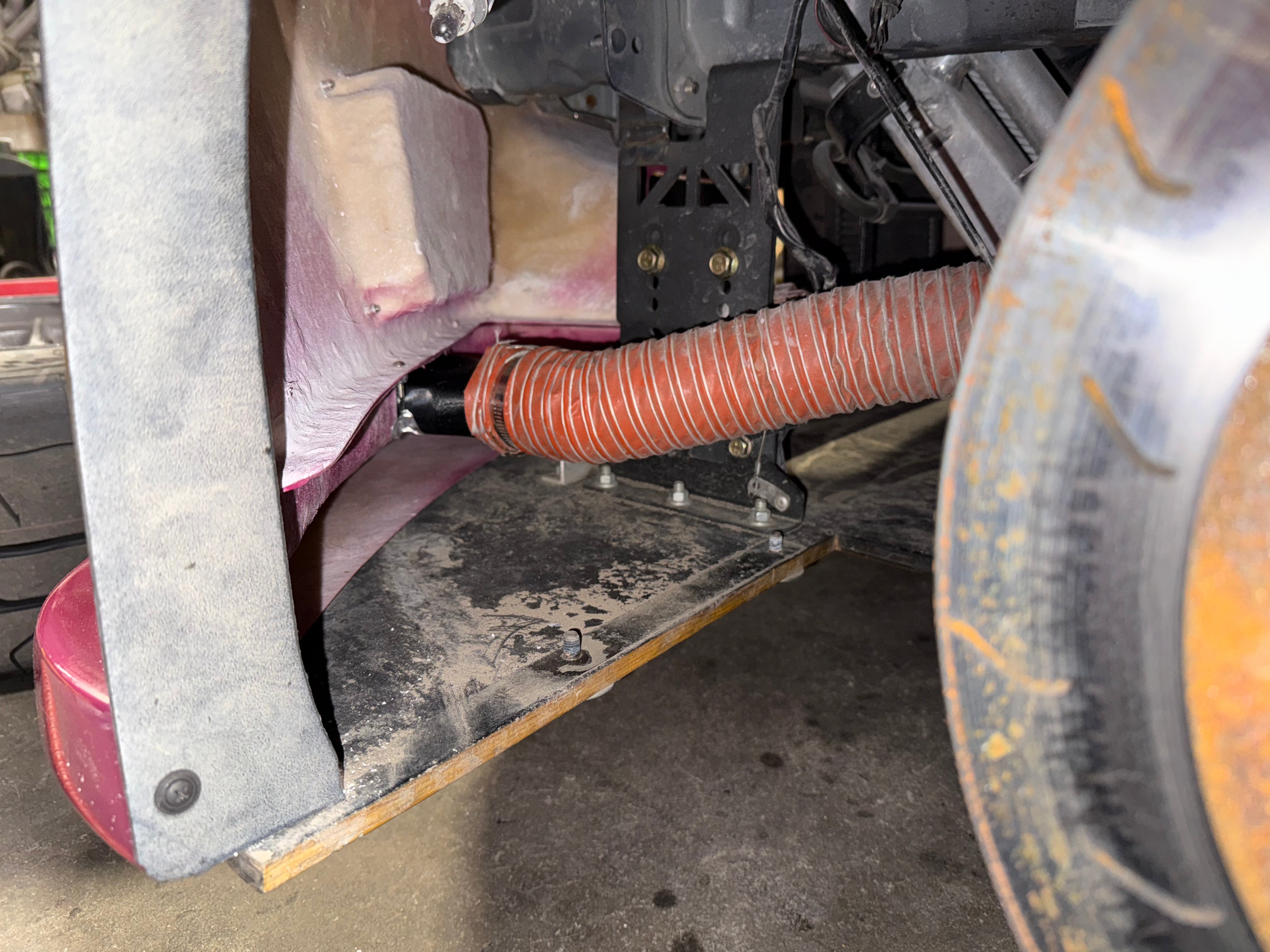 Close-up of a brake duct inlet installed behind the front wheel of a Miata NC