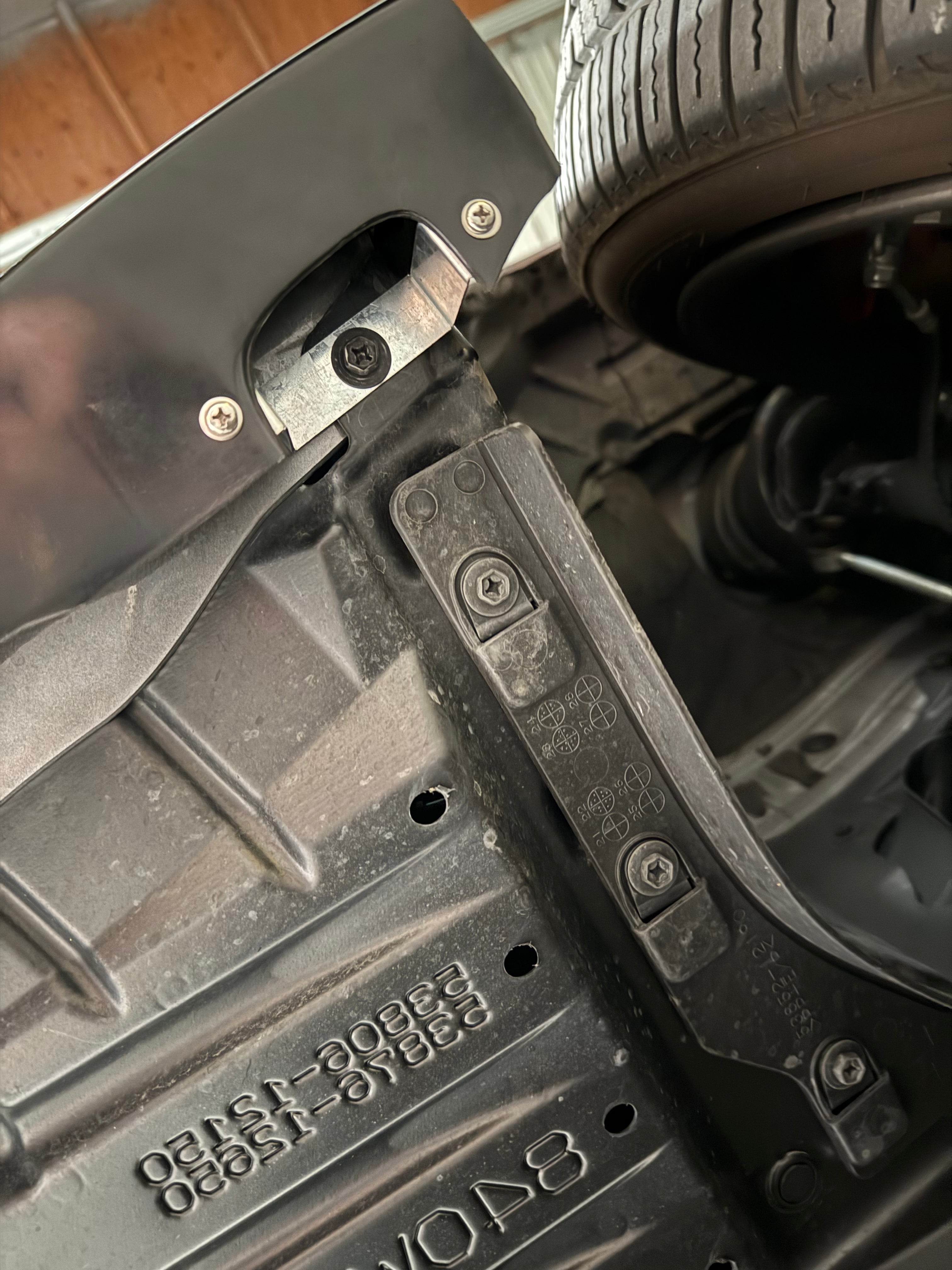 Close-up of the front lip mounting bracket and OEM hardware on a GR Corolla Kouki