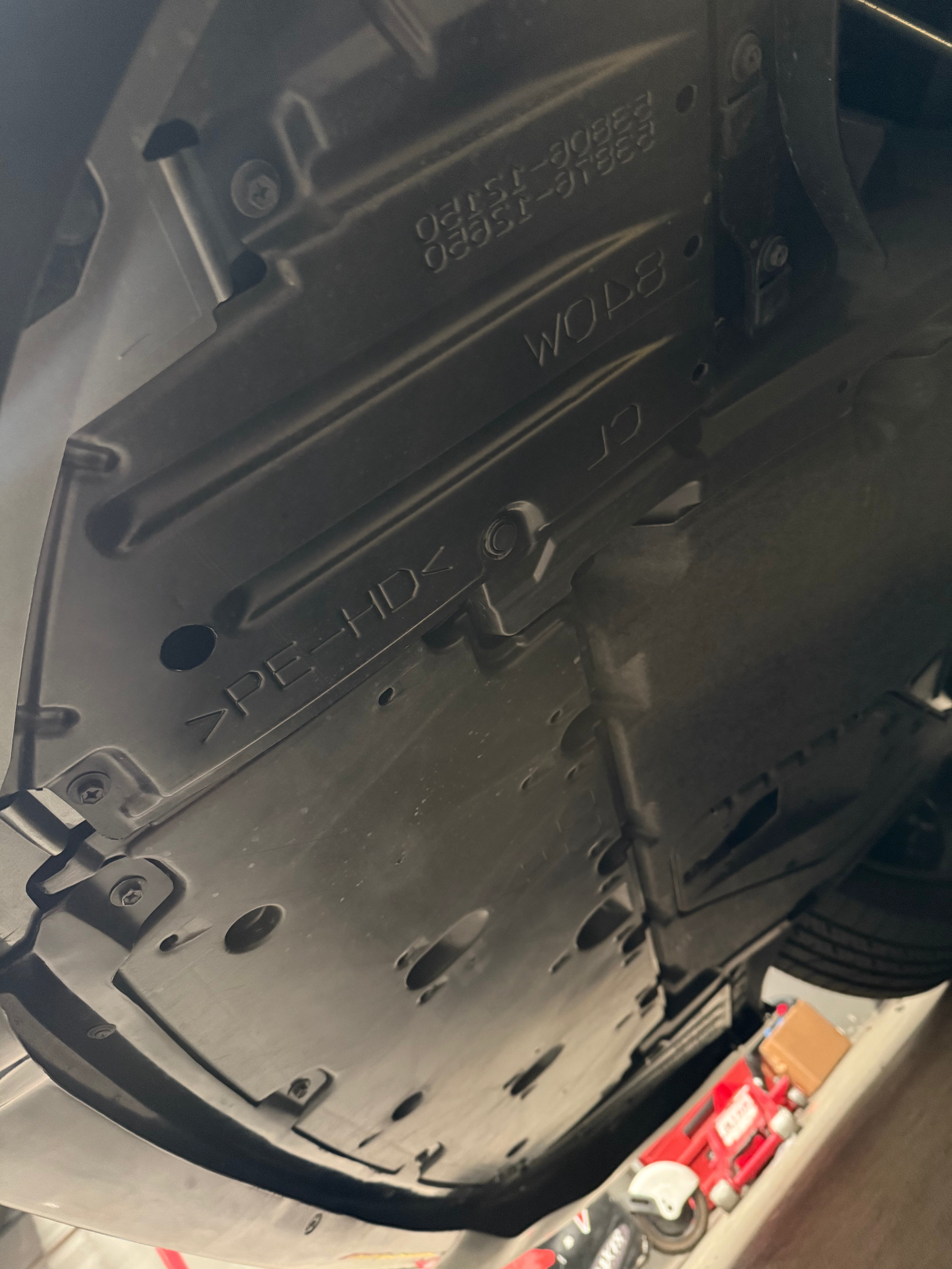 Underside view of the front lip mounting hardware on a GR Corolla Kouki