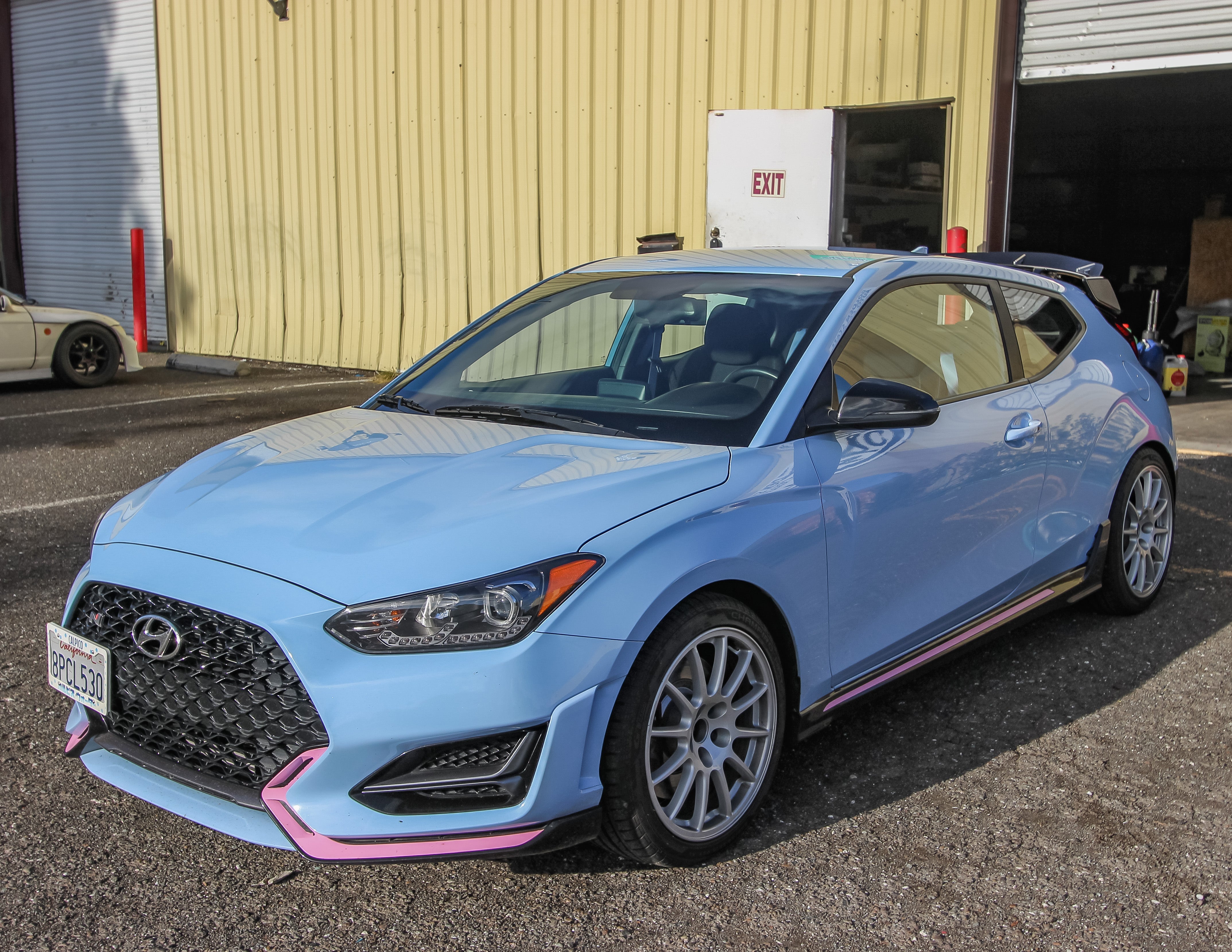 Front three-quarter view of a light blue Veloster N JS with spoiler extension