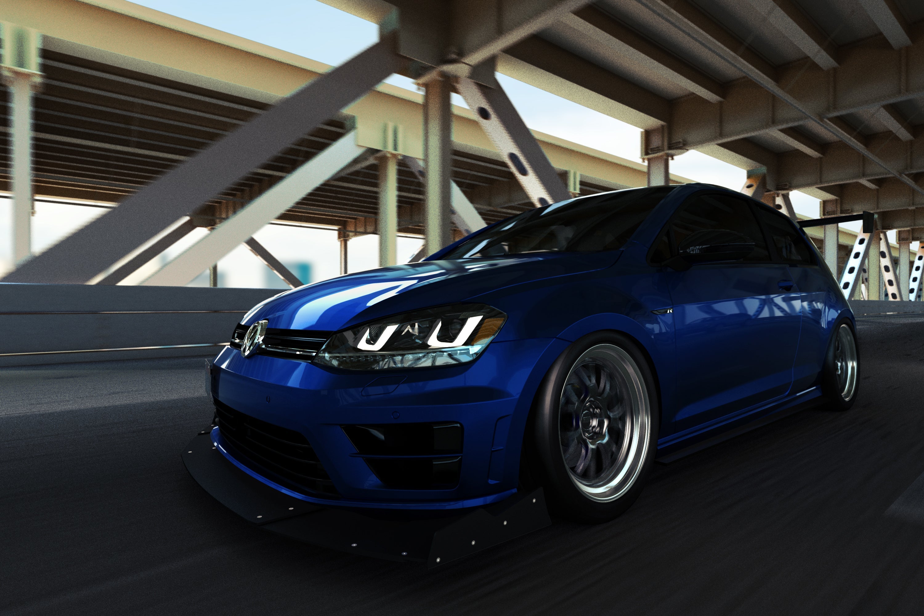 Front three-quarter view of a blue Golf R with GT wing parked under a bridge
