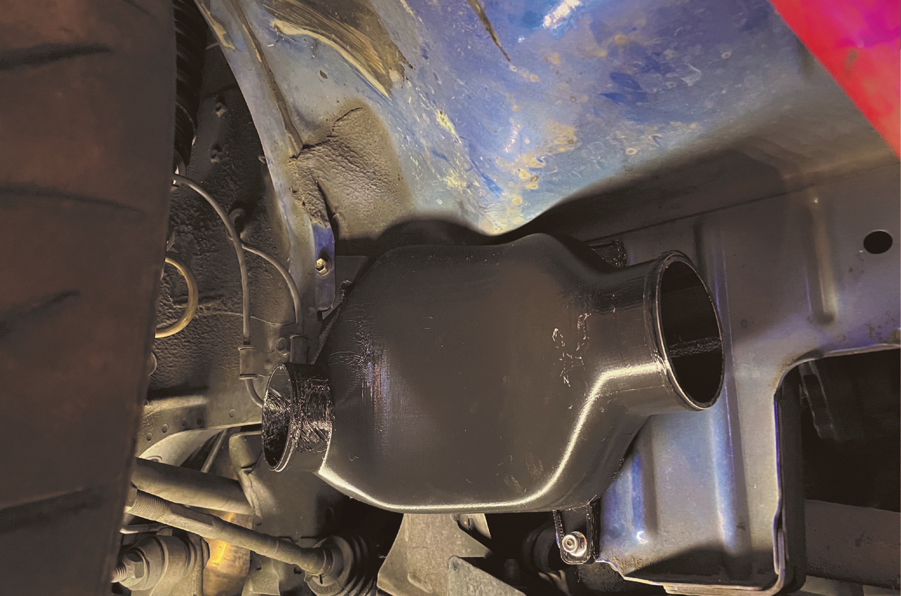 Pancake duct installed behind the front fender liner on an Impreza GD/GG