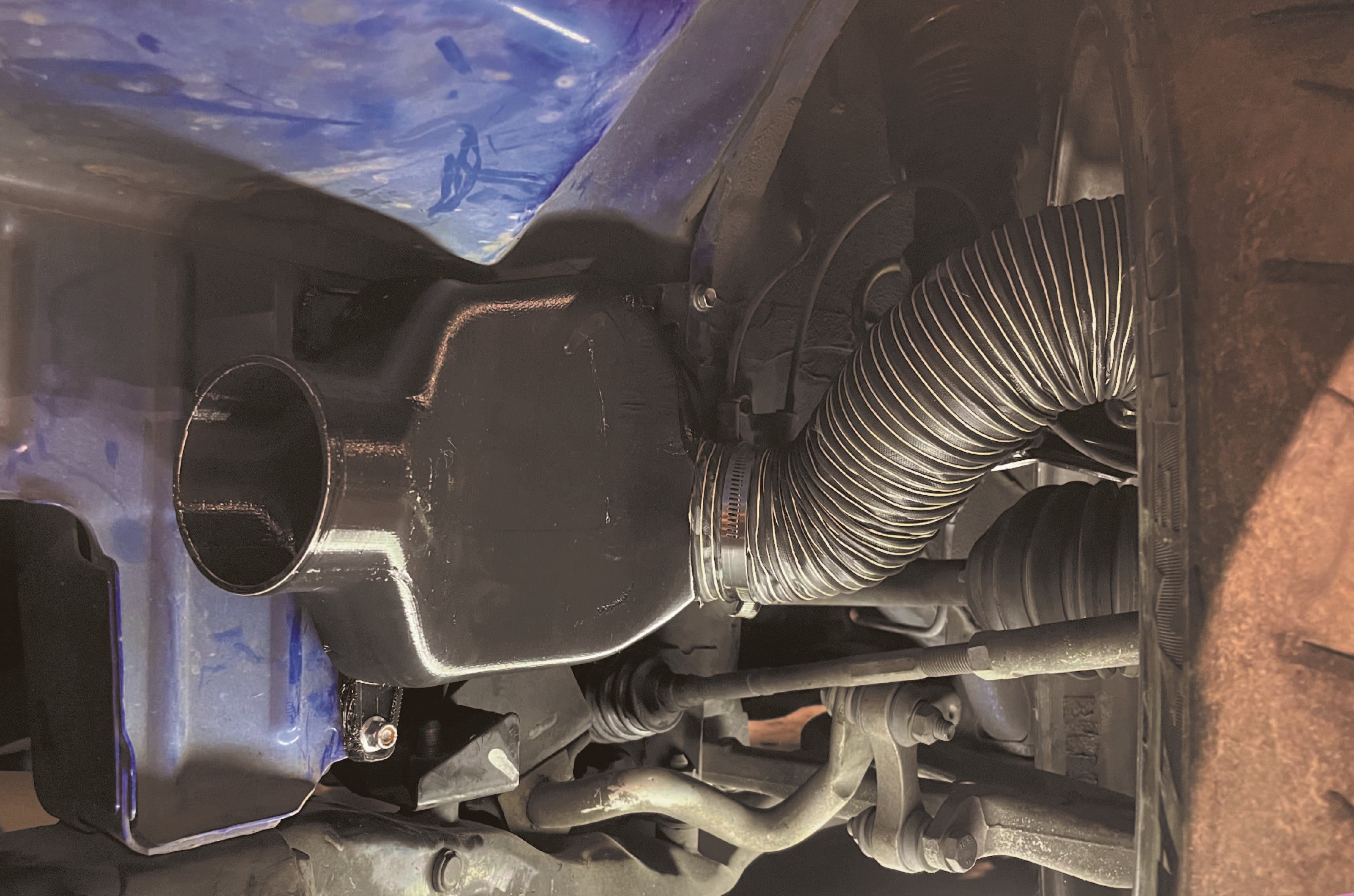 Installed brake duct routing hose visible behind the wheel on an Impreza GD/GG