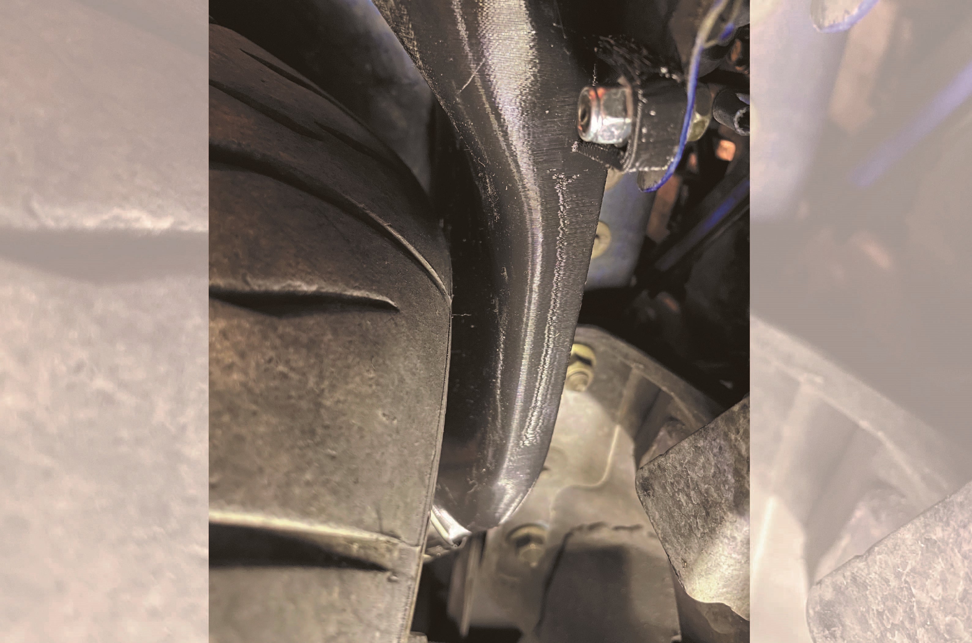 Close-up of the installed pancake duct and hose clamp behind the fender liner