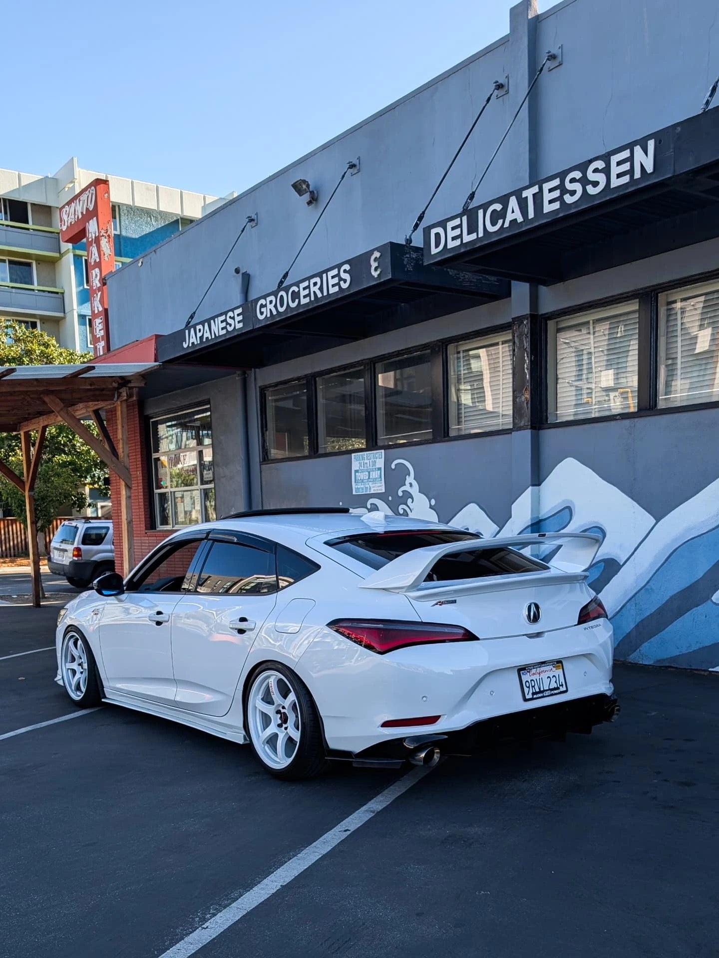 Rear three-quarter view of a white Acura Integra with the Epsilon+ Sport Wing