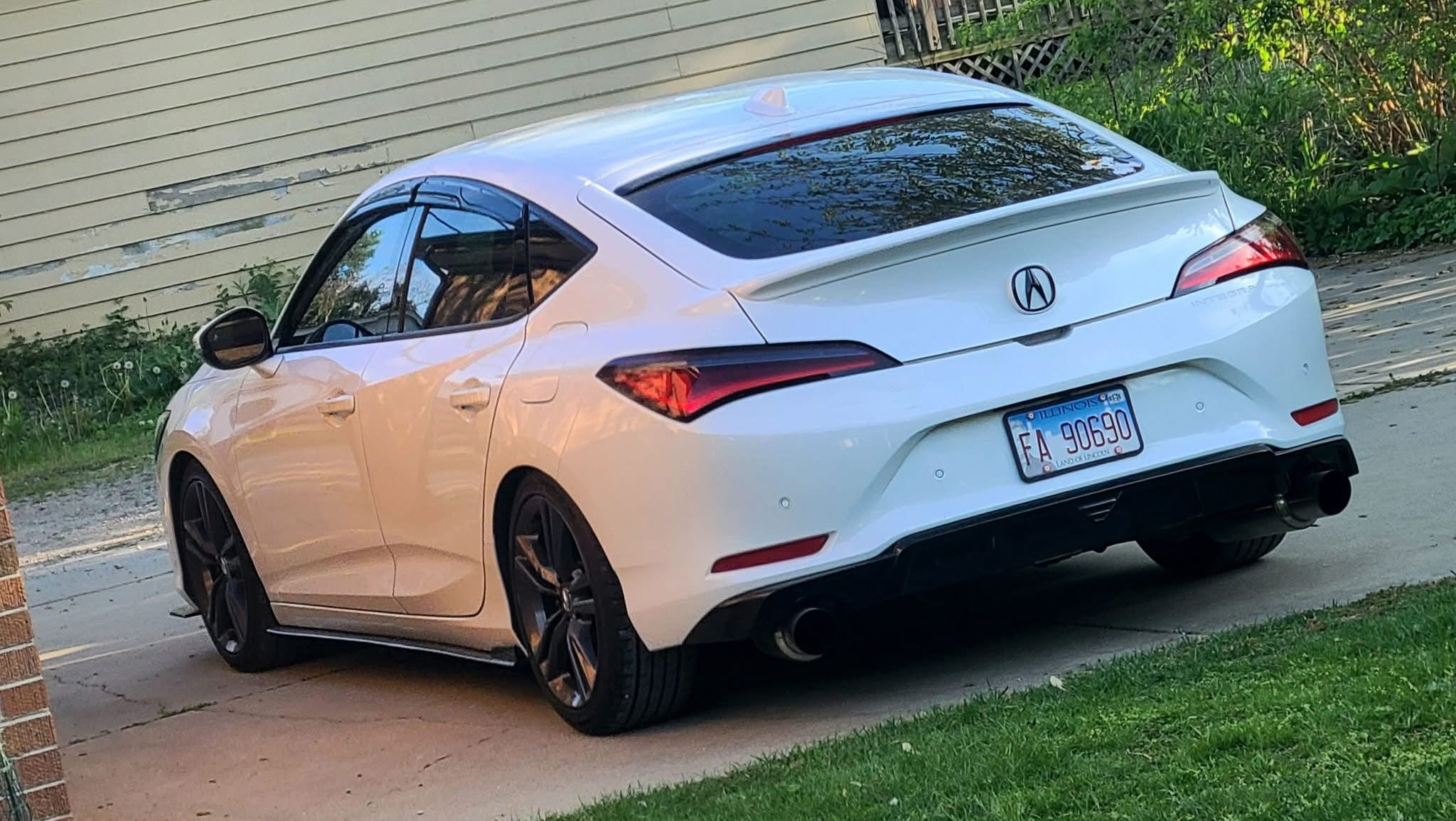 White Acura Integra with the Epsilon+ rear trunk lip, rear three-quarter view
