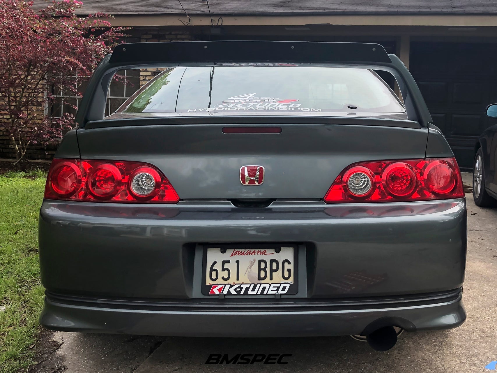 Rear view of a gray Acura RSX with A-Spec spoiler extension in a driveway