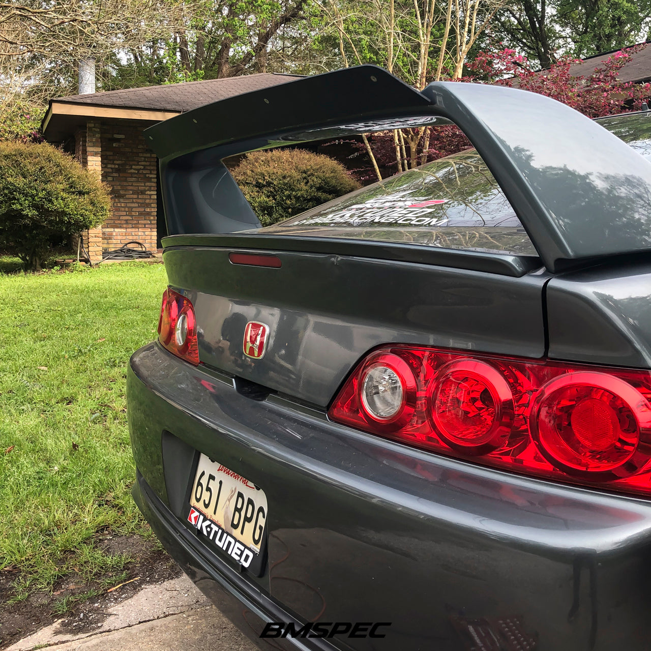 Rear three-quarter view of a gray Acura RSX with A-Spec wing spoiler extension