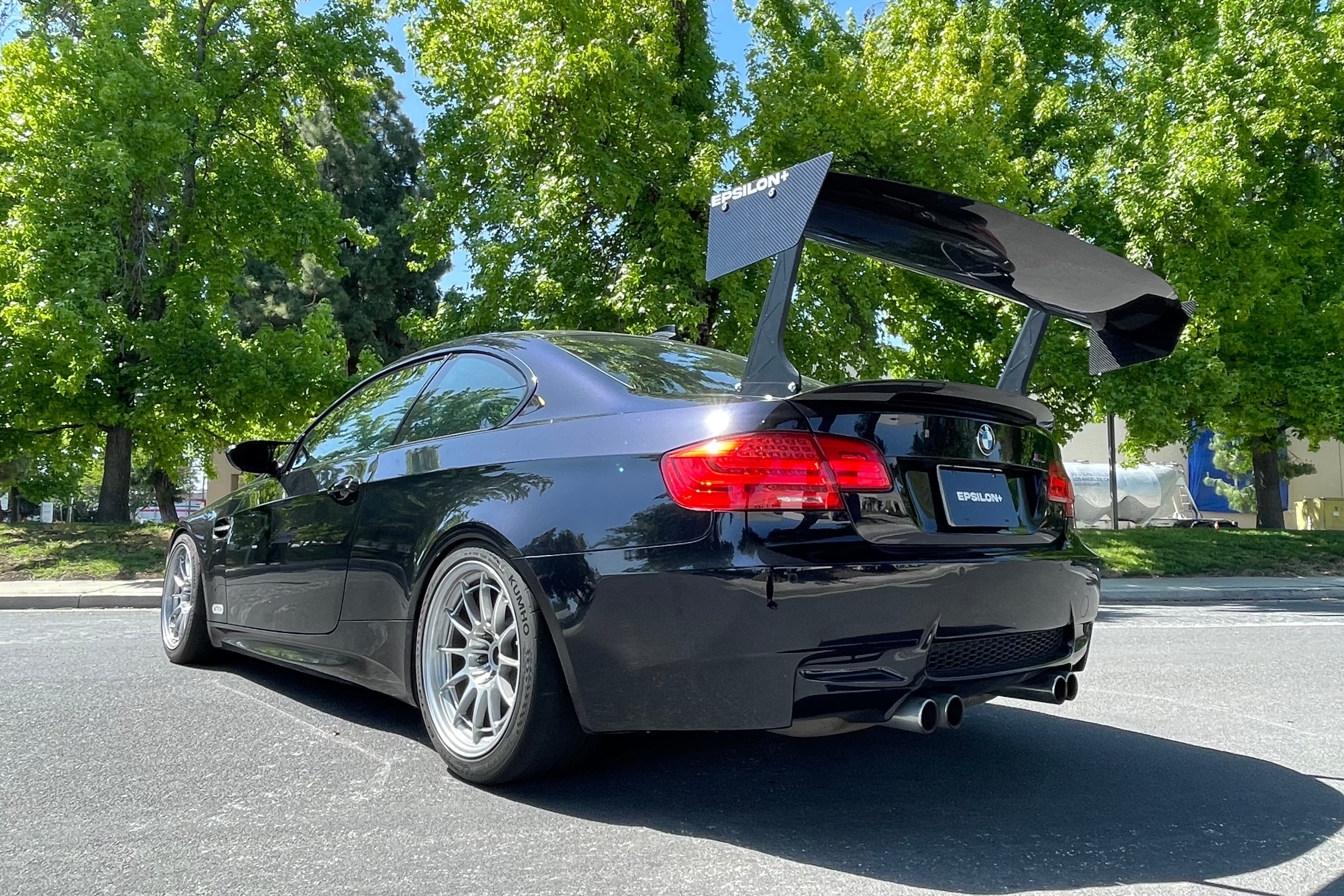 Rear three-quarter view of a black BMW E92 M3 with the Epsilon+ GT wing