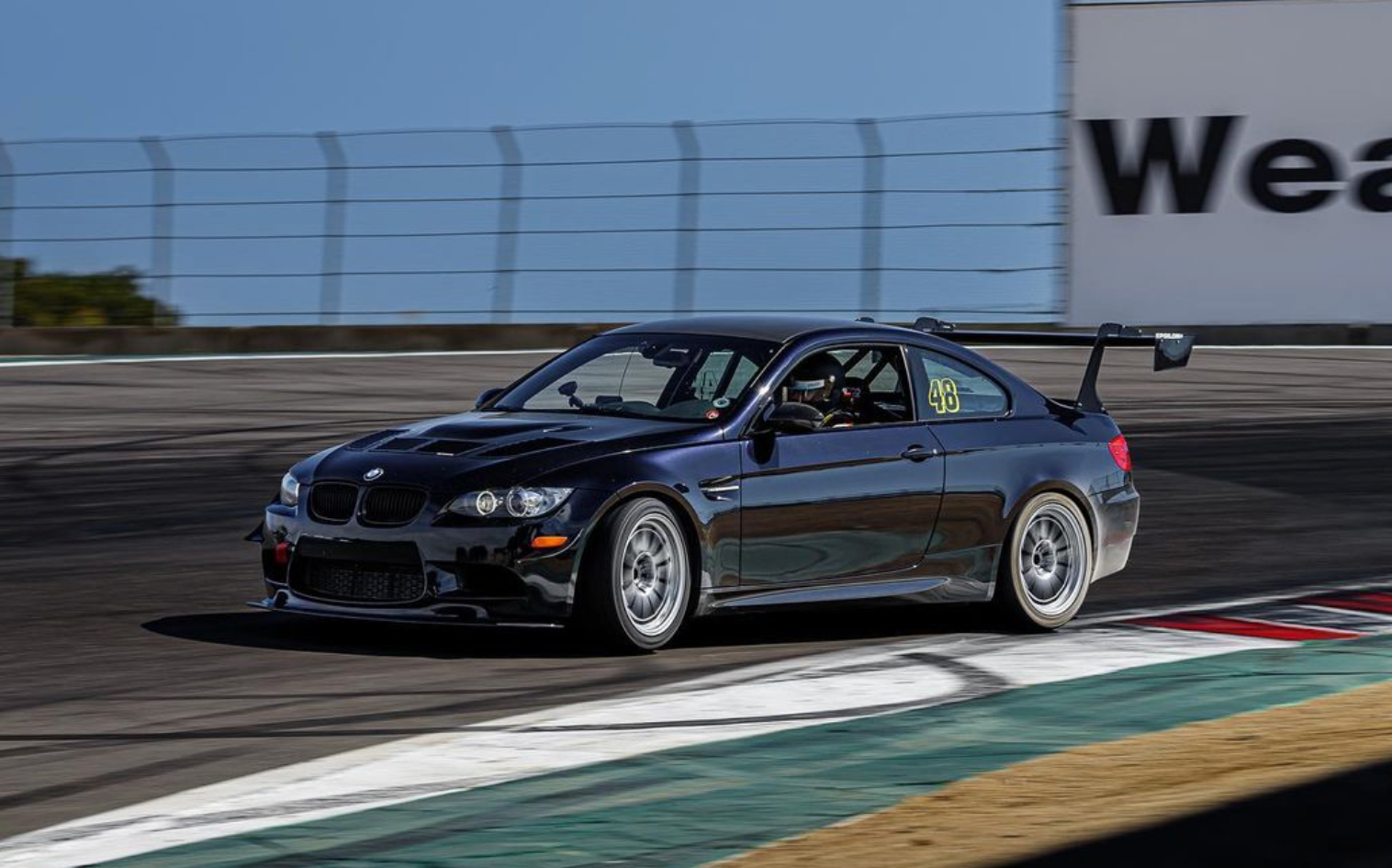 Black BMW E92 M3 with the Epsilon+ GT wing on a race track