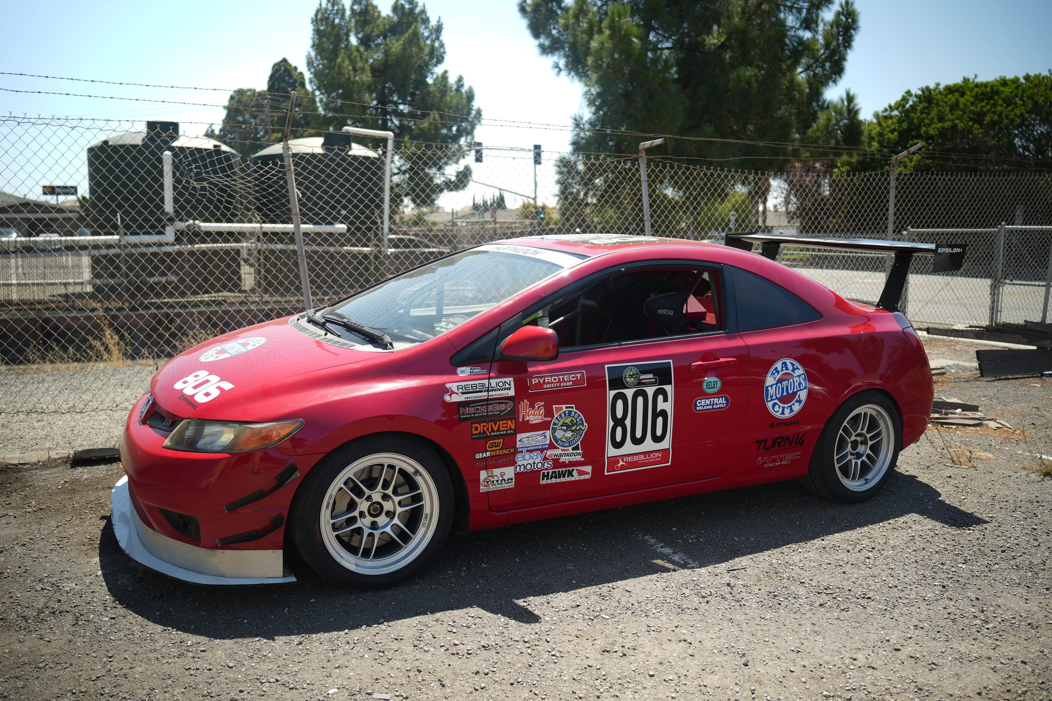 Front three-quarter view of a red Civic Coupe FG2 motorsport car with GT wing