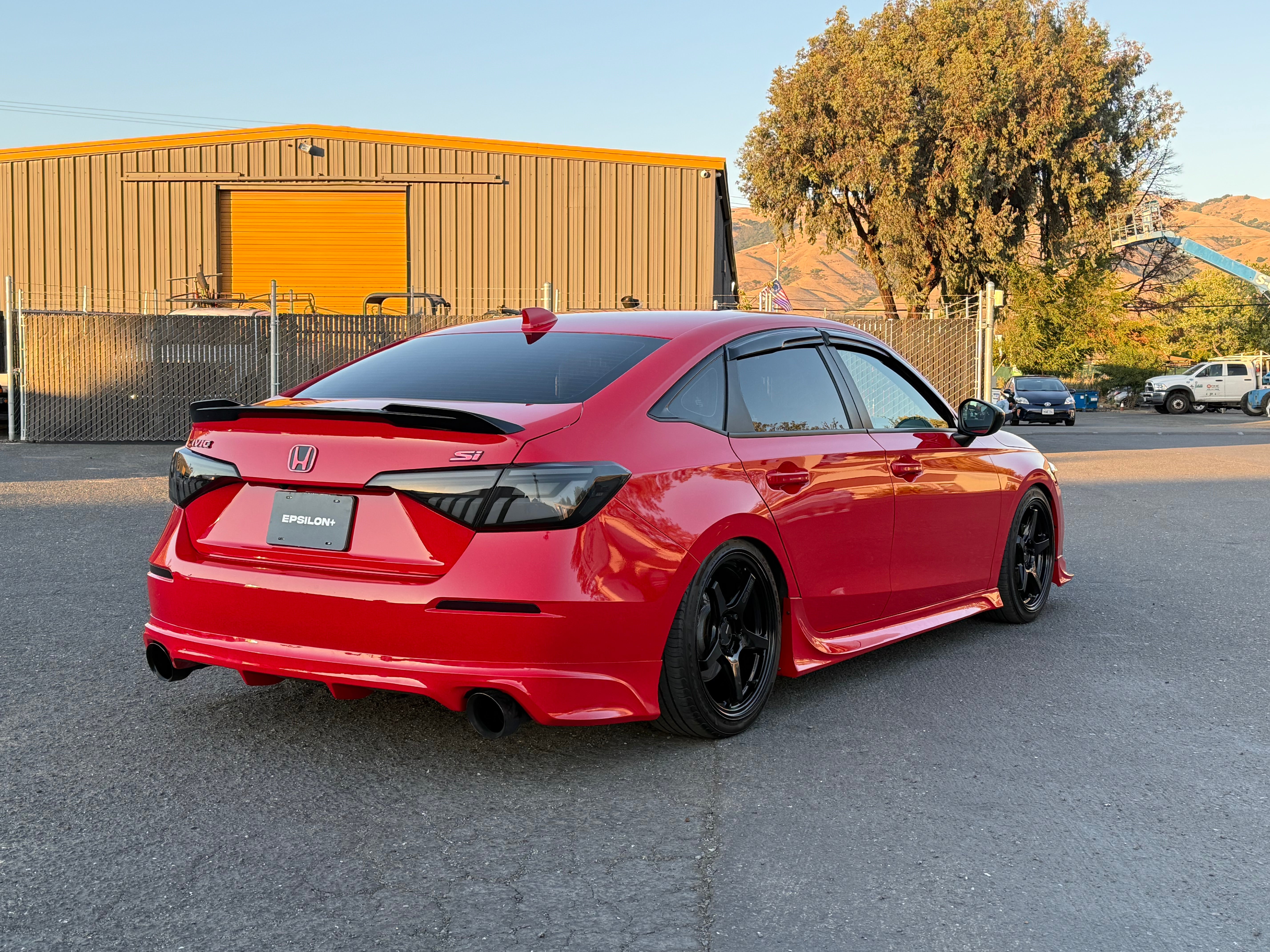 Side-rear view of a red Honda Civic Sedan with the Epsilon+ rear lip