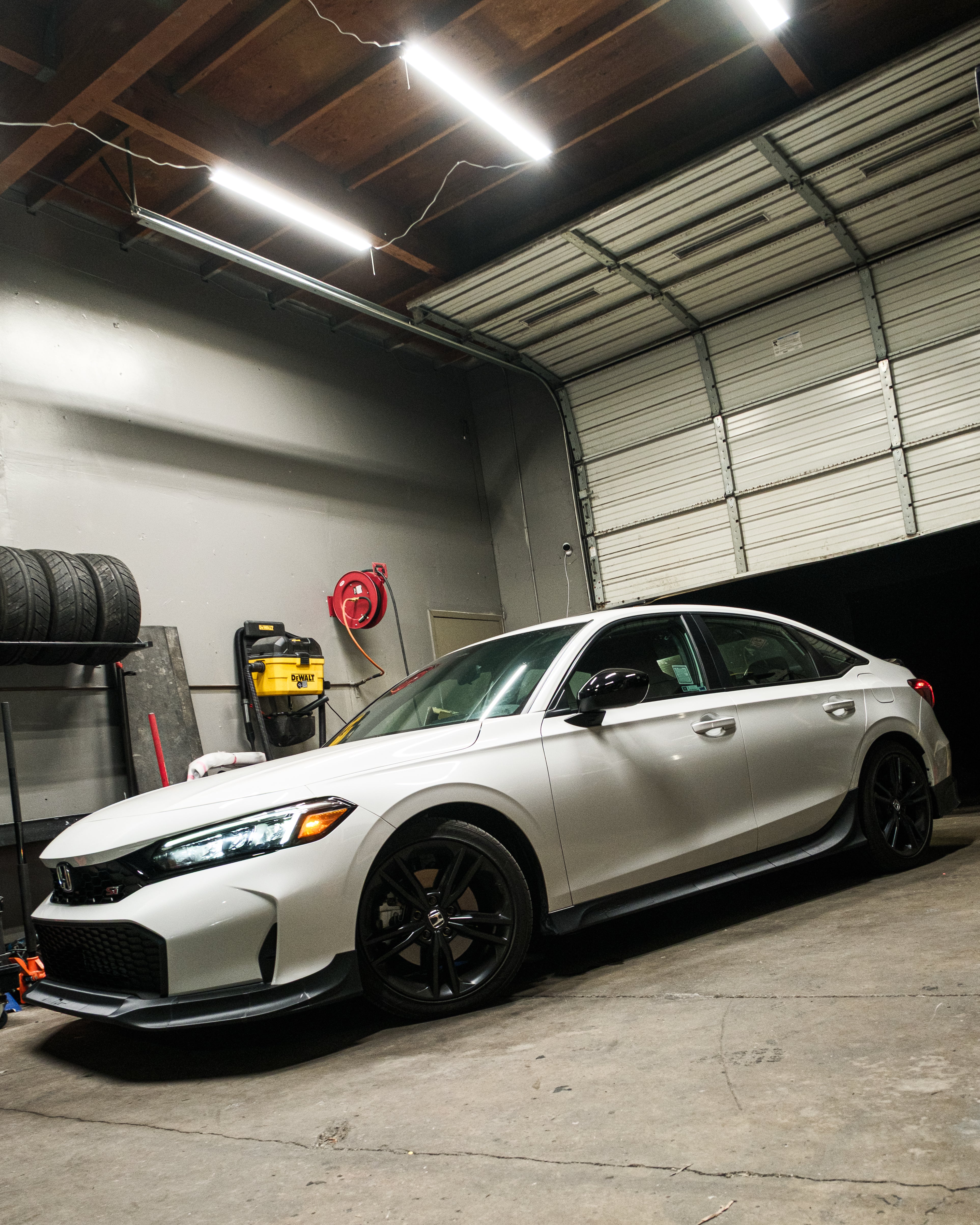 White Honda Civic with the Epsilon+ side skirts inside the workshop
