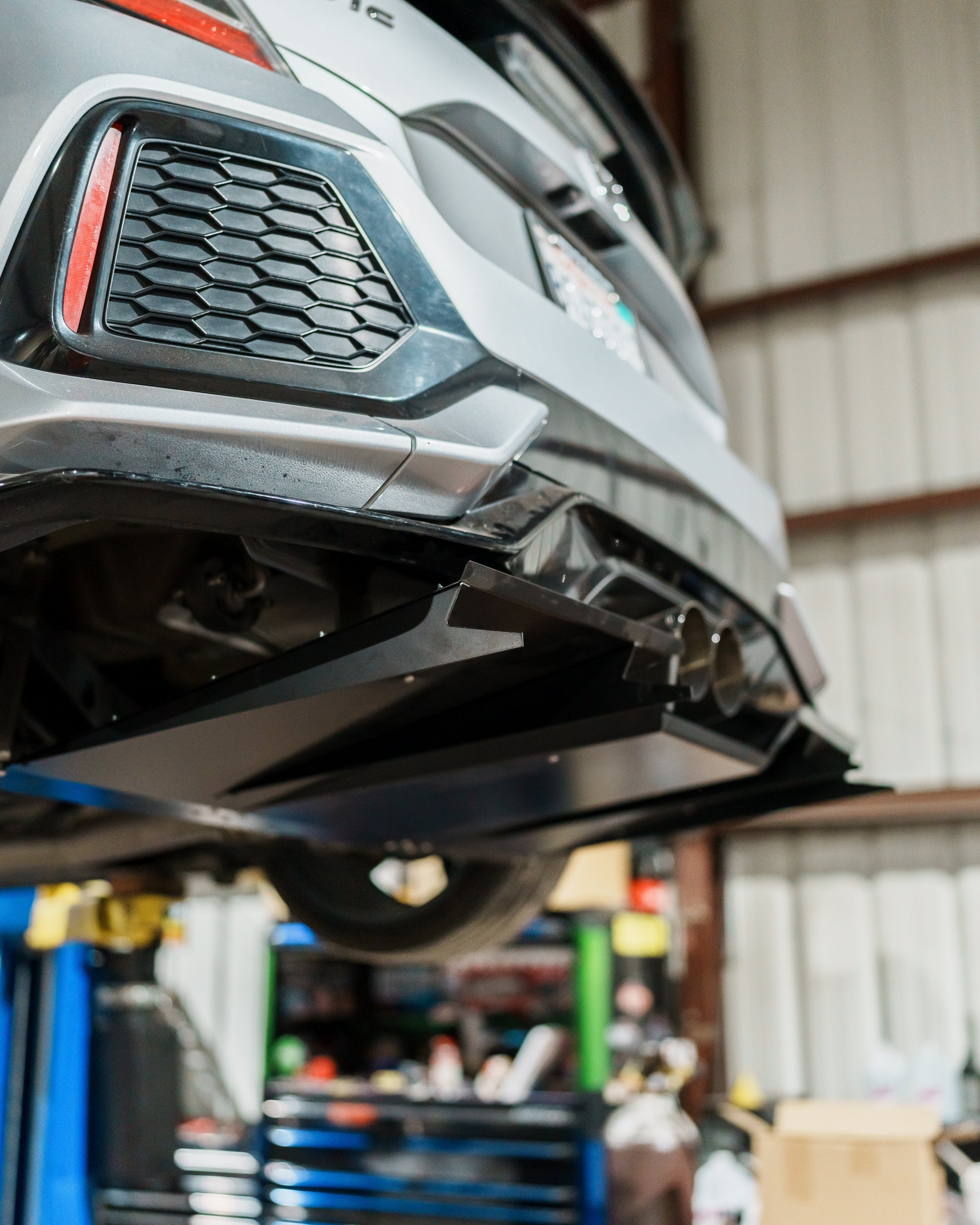 Honda Civic FK7 raised on a lift showing the underside before V1C+ diffuser installation