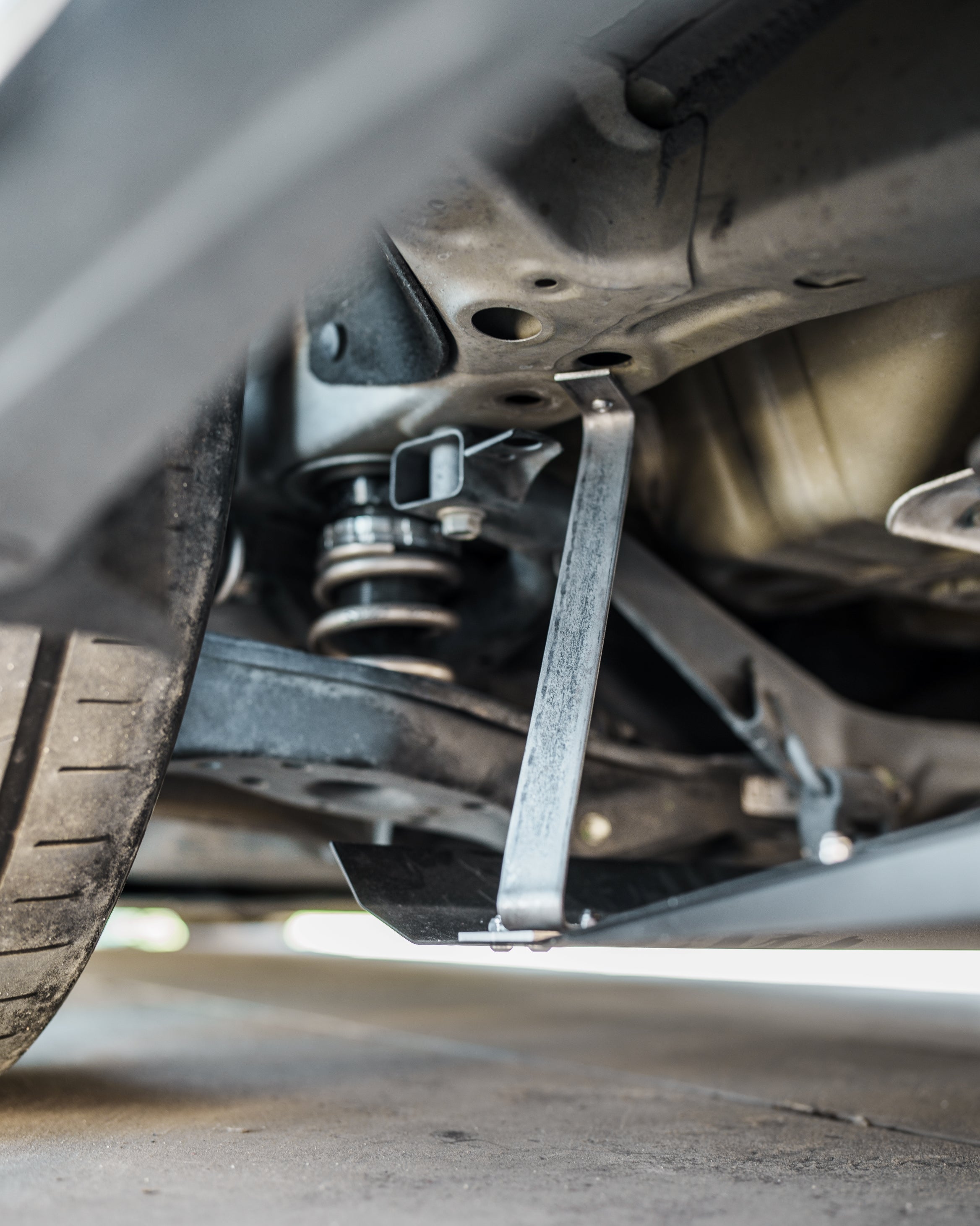 Underbody view of the V1C+ diffuser support bracket near the Civic FK7 rear suspension