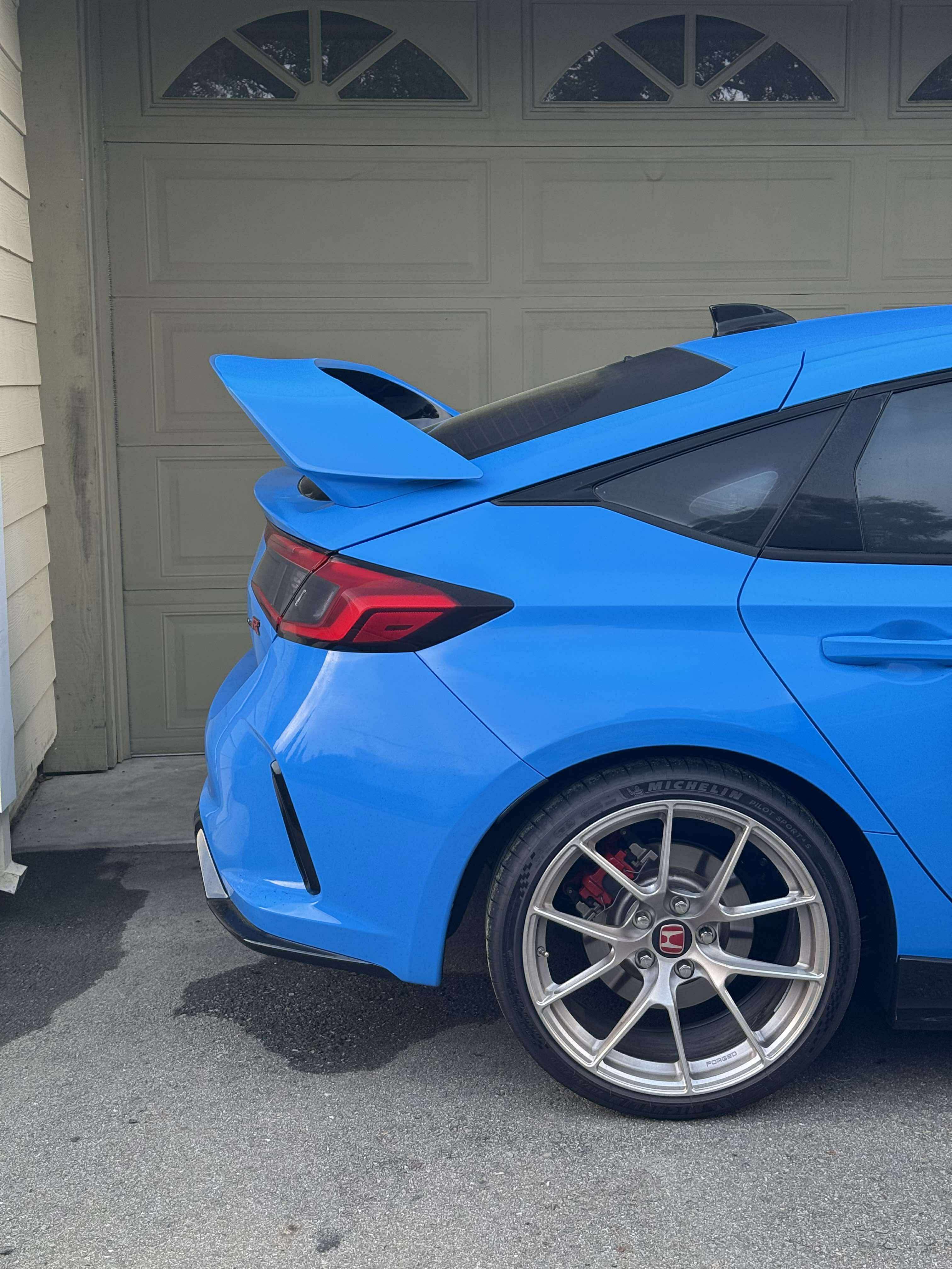 Close rear three-quarter view of the Sport Wing on a blue Honda Civic FL5
