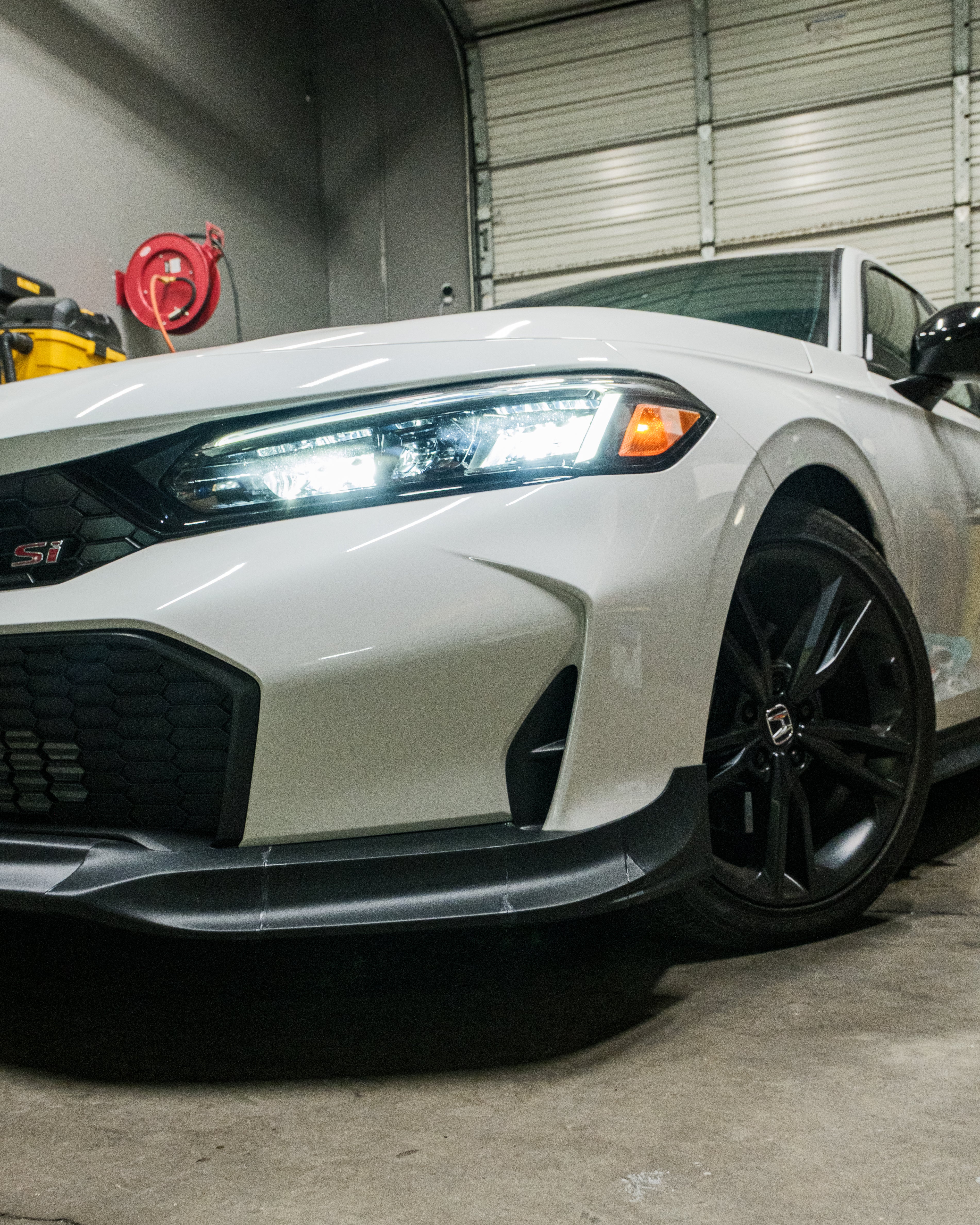 Close front corner view of the Epsilon+ front lip on a white Honda Civic