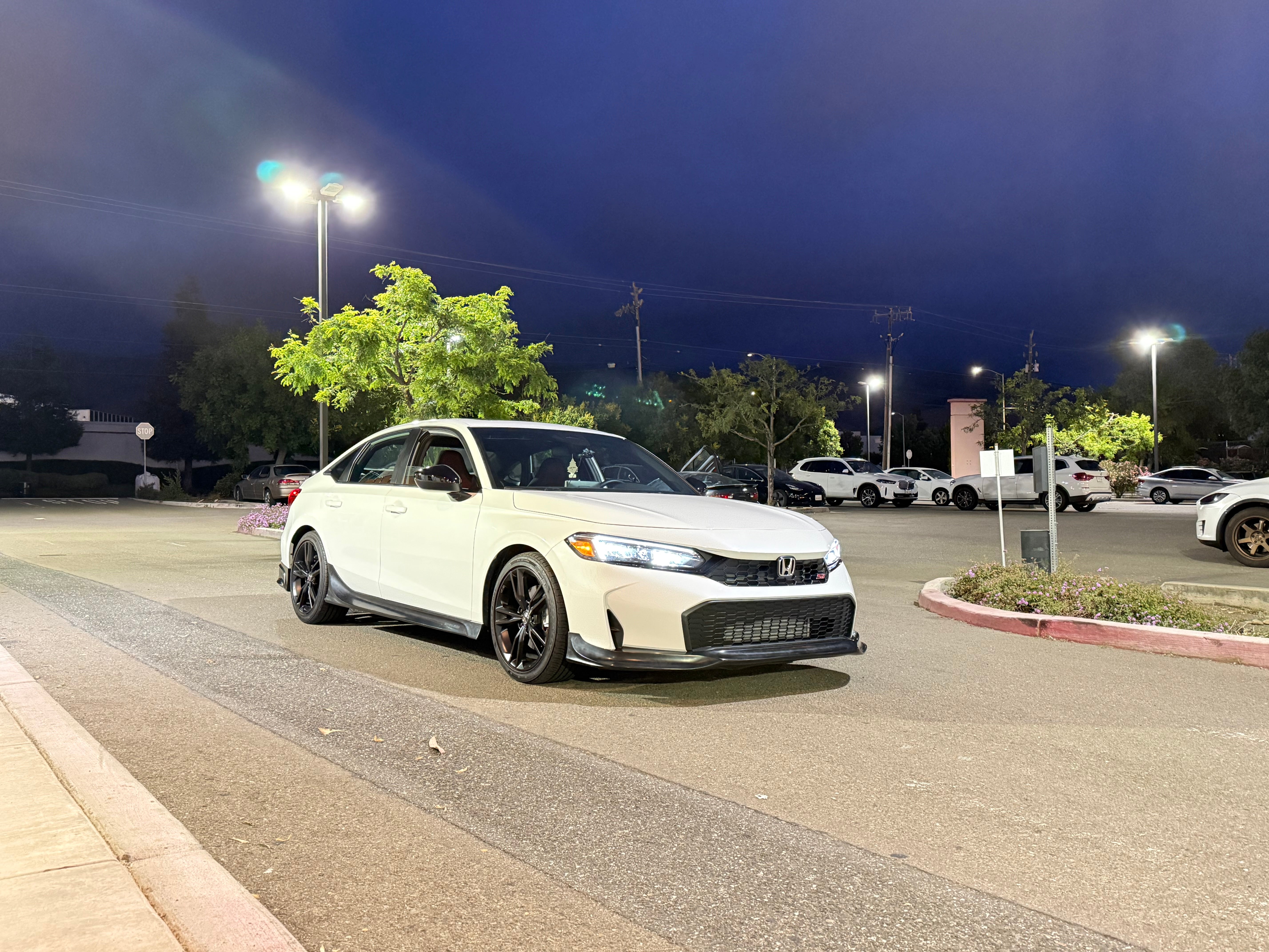 White Honda Civic Kouki with front lip in a parking lot at dusk