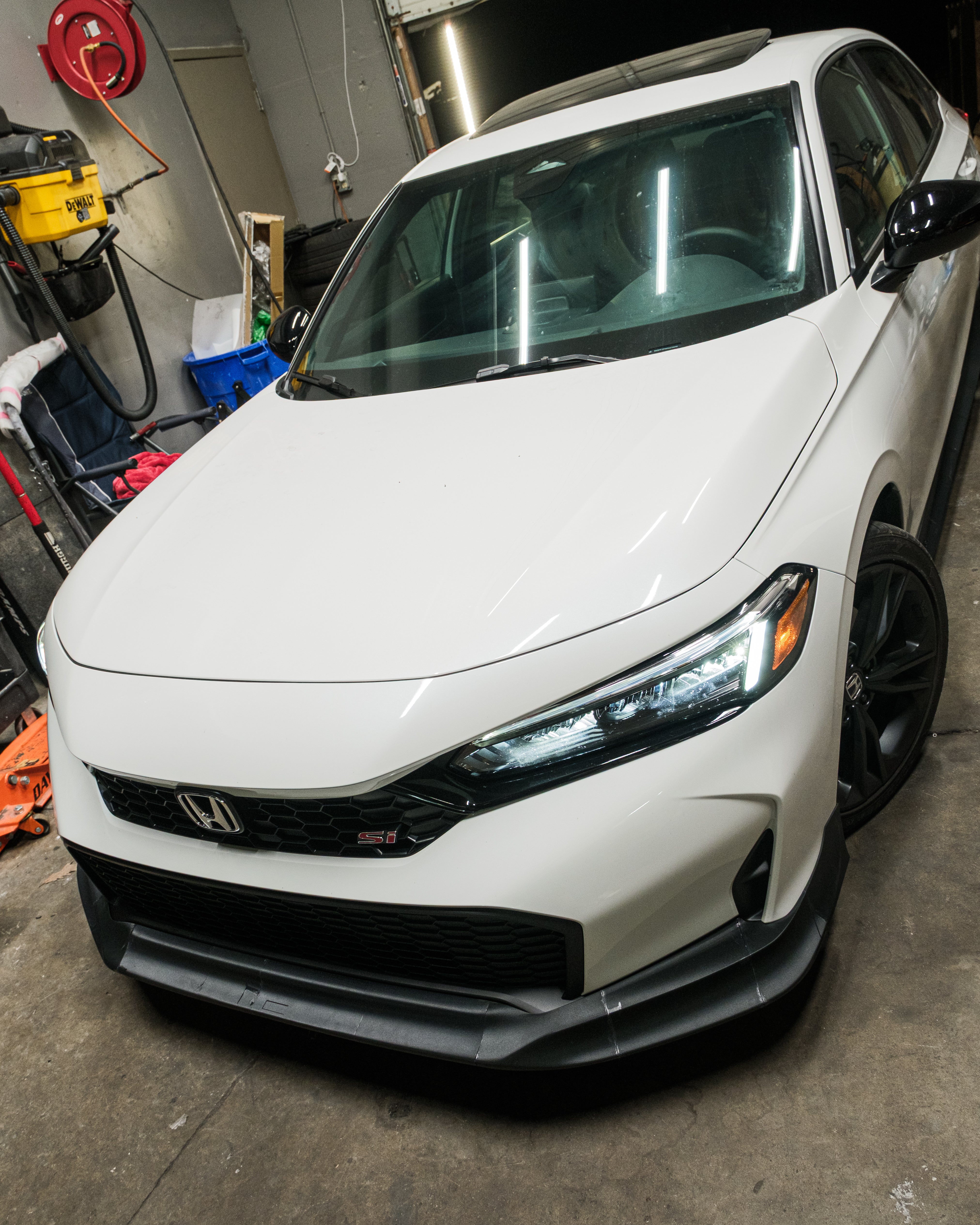 White Honda Civic with Epsilon+ front lip inside the workshop